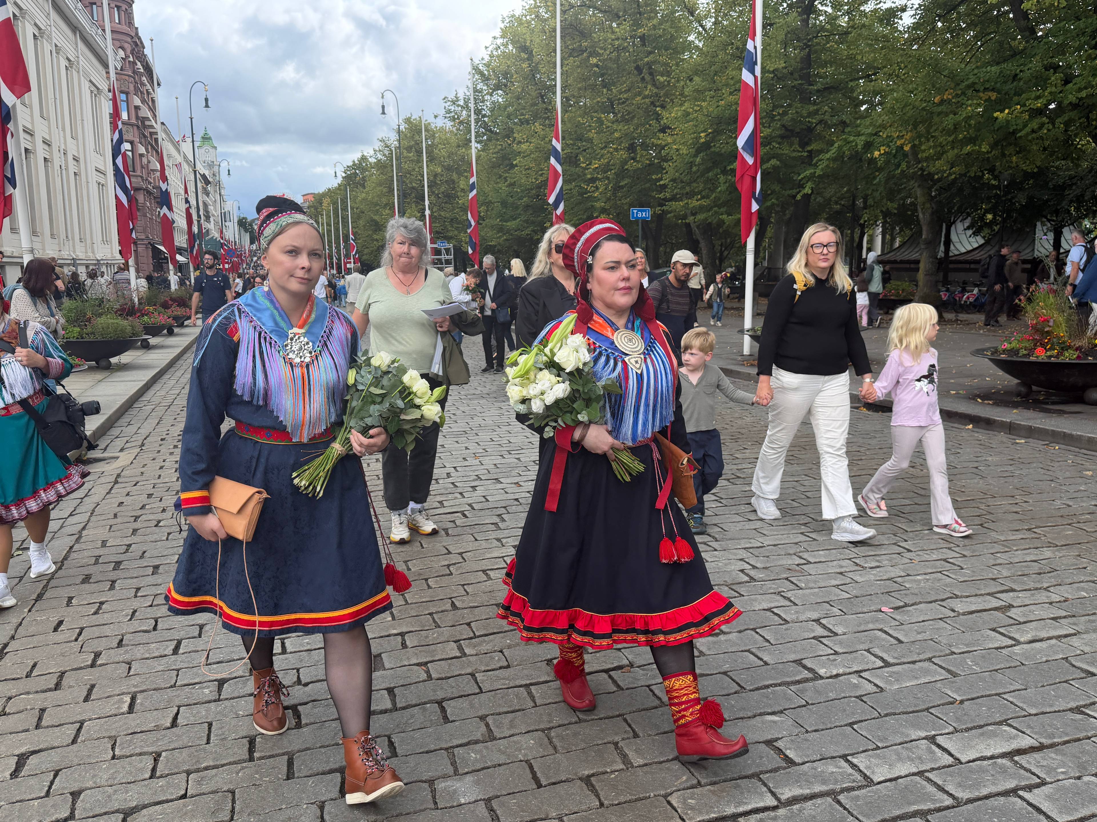 to kvinner i kofte som holder blomster mens de går