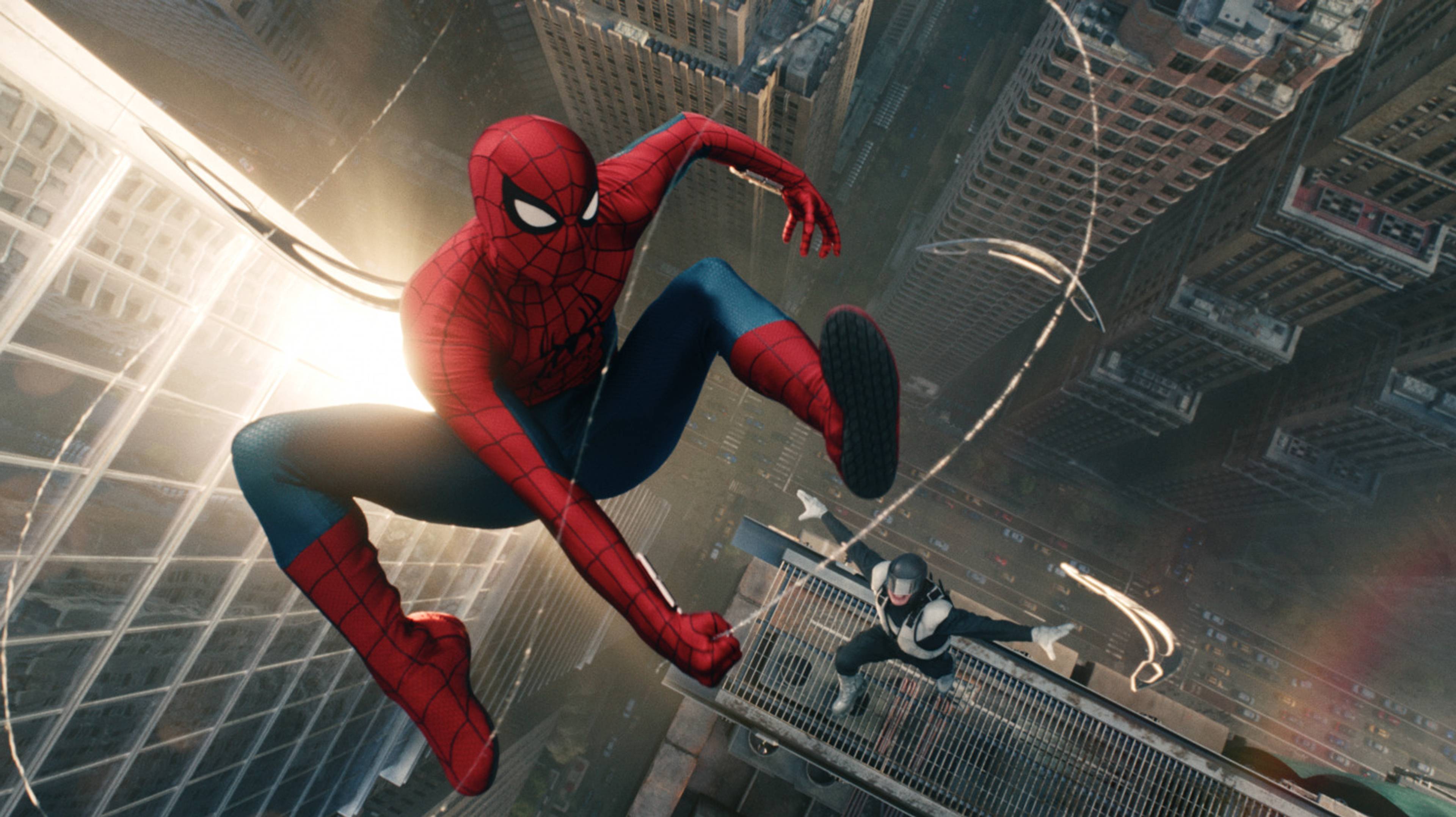 Spider-man slenger seg mellom store bygningar med ein skurk på slep.