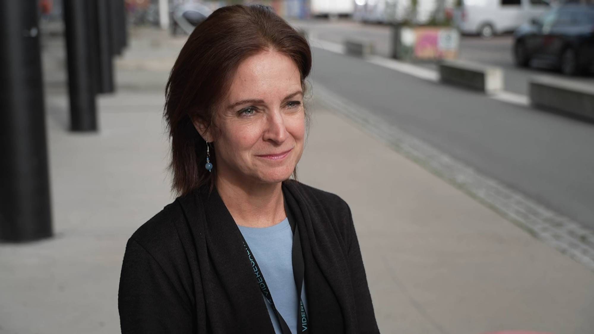 Melissa Lee Bonvik har skulderlangt, brunt hår, svart blazer og blå t-skjorte. 