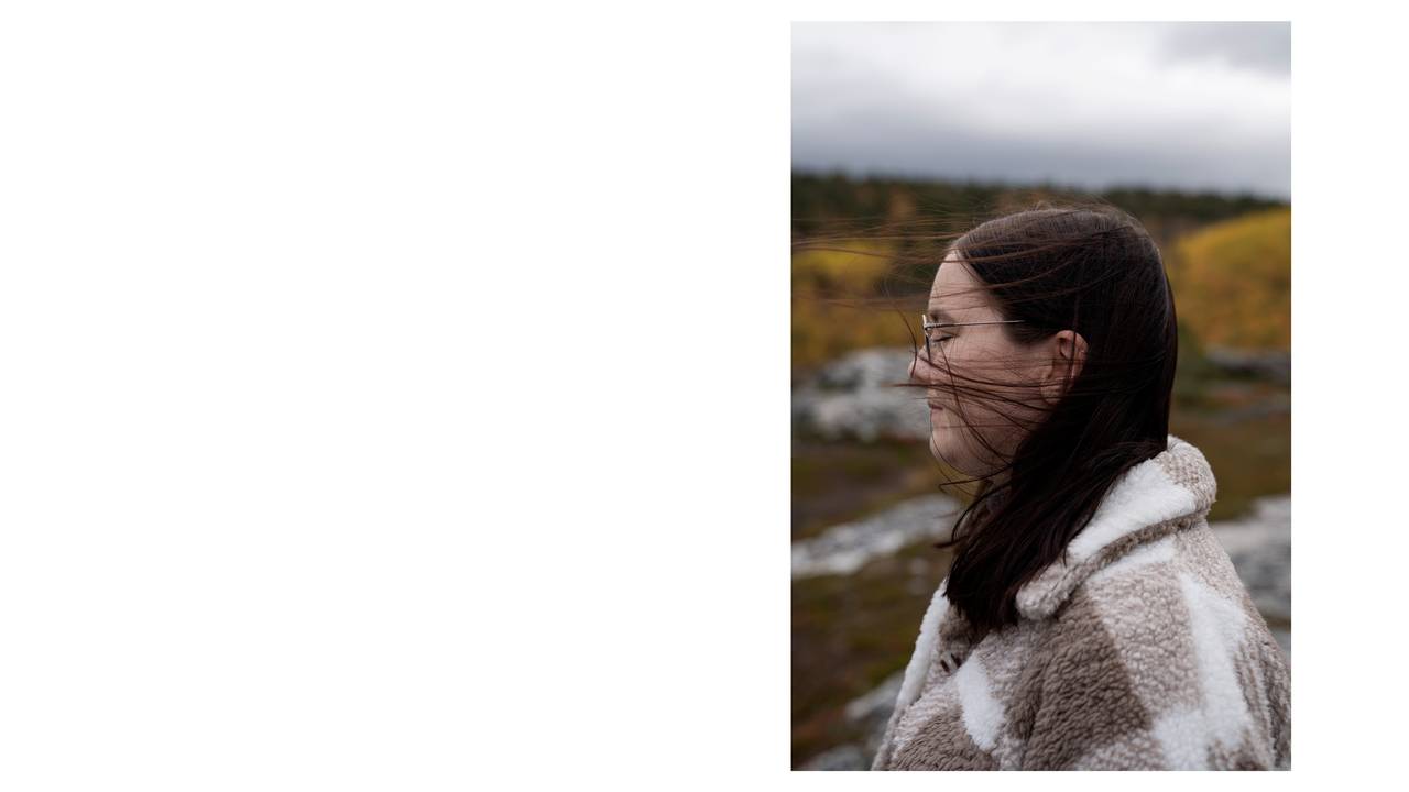 Maria (20) lukker øynene et øyeblikk mens hun står ved Altafjorden. 