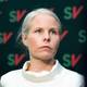 Daniil Thorkild Ryvænge / NRK Kirsti Bergstø i hvit overdel ser alvorlig ut. I bakgrunnen en vegg med mange små SV-logoer på