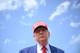 MANDEL NGAN / AFP,NTB Donald Trump står med en rød caps med påskriften "Make America Great Again". Han har på seg en blå dressjakke og et rødt slips. Bildet er tatt utendørs med en blå himmel og hvite skyer i bakgrunnen. (Bildebeskrivelsen er laget av en KI-tjeneste)