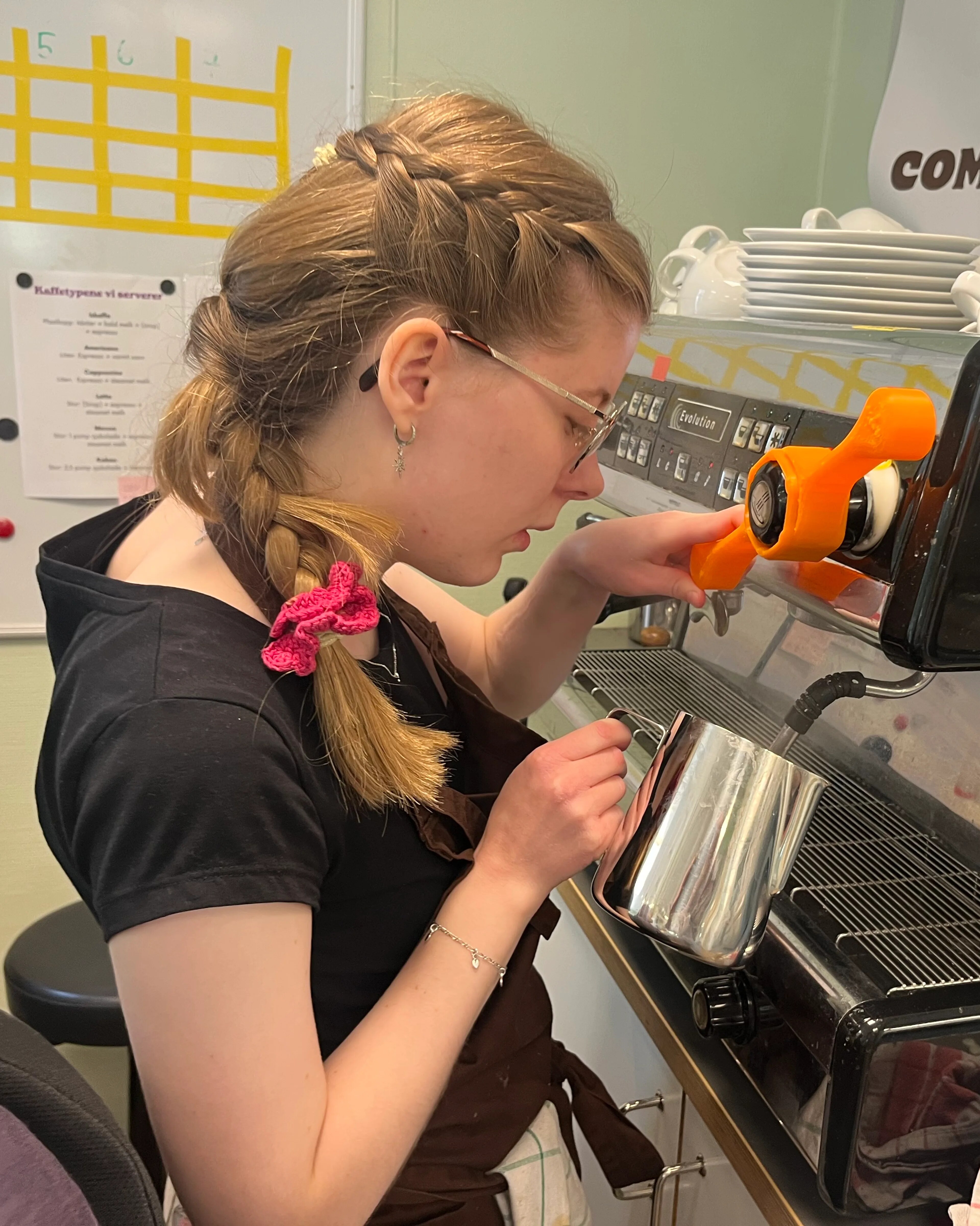 ung same som lager kaffe på en kaffemaskin