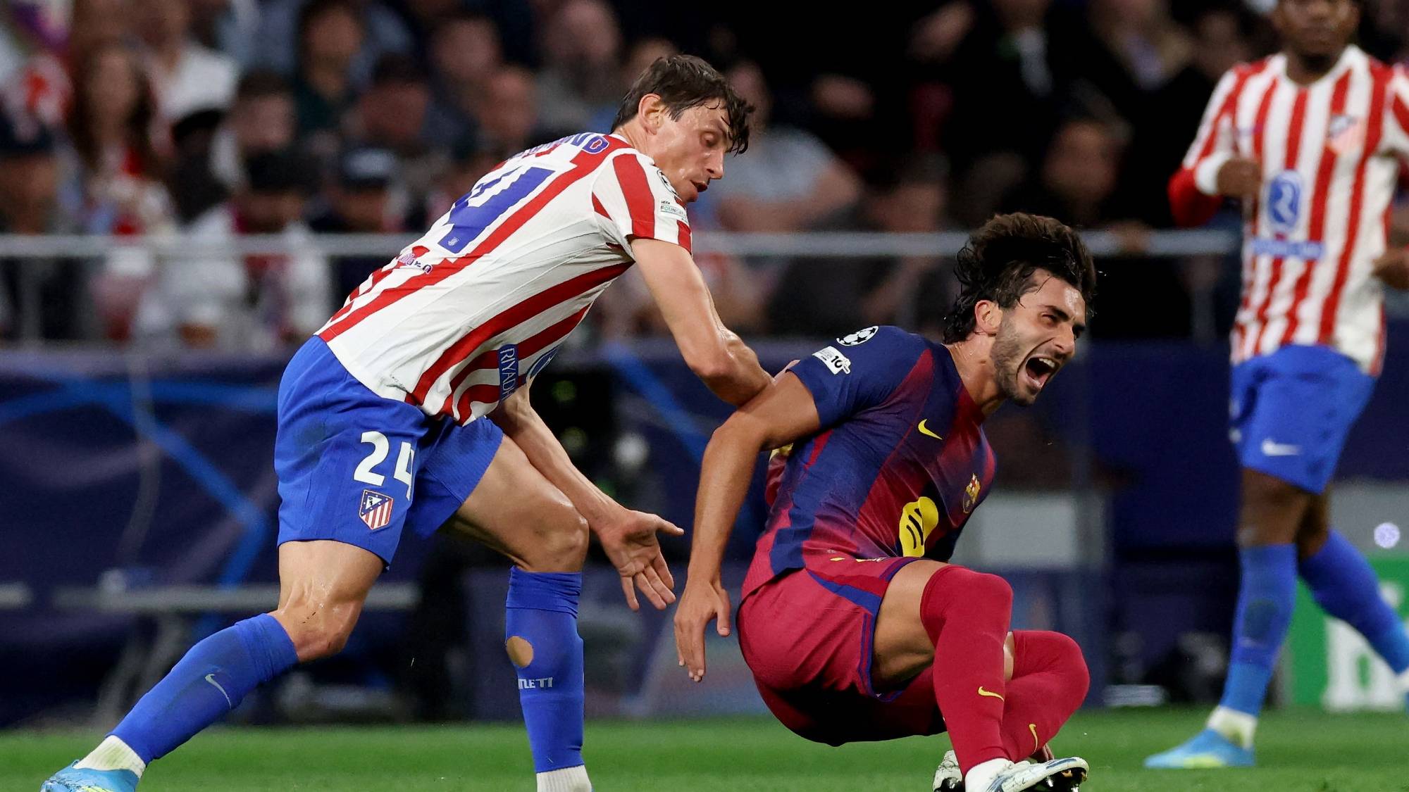 En fotballspiller fra Atletico Madrid presser en Barcelona-spiller som faller på gresset. (Bildebeskrivelsen er laget av en KI-tjeneste)