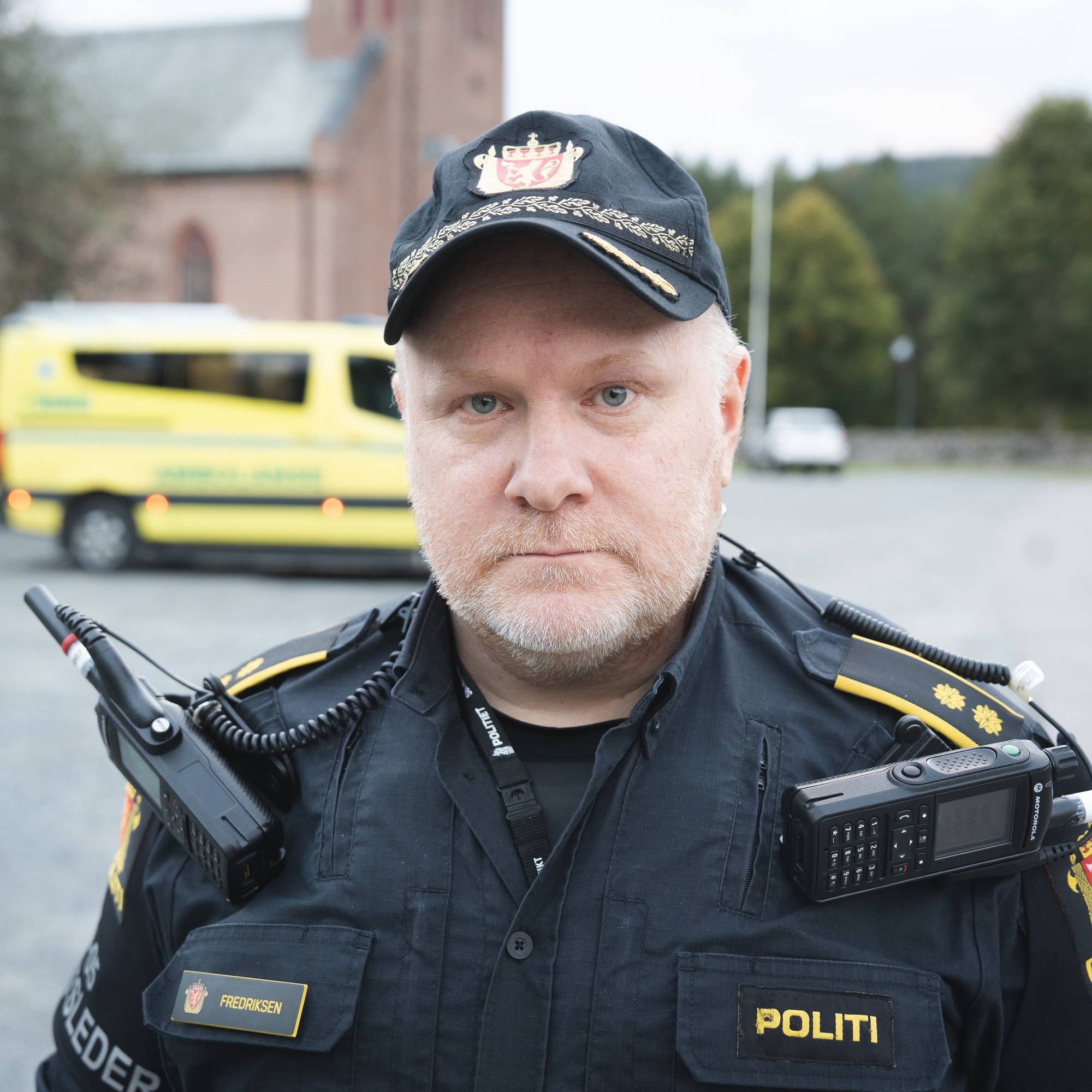 Politimann foran ambulanse og kirke