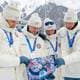 Heiko Junge / NTB Fire utøvere i hvite jakker og luer ser på et bilde av avdøde Sivert Guttorm Bakken med norsk flagg. De bærer alle medaljer rundt halsen. Bakgrunnen viser snødekte fjell og tribuneanlegg. (Bildebeskrivelsen er laget av en KI-tjeneste)
