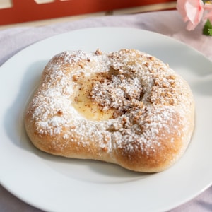 En mandelbolle med melis og mandelstrø.