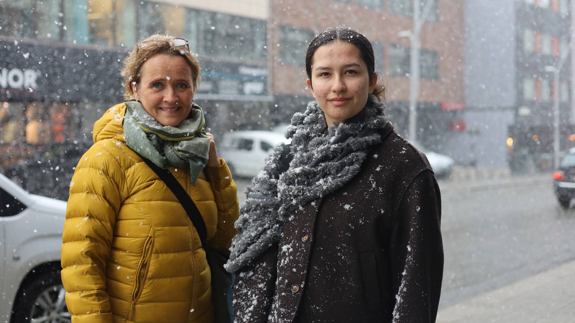 To kvinner står i snøværet i tromsø