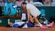 Stephanie Lecocq / REUTERS,NTB En tennisspiller ligger på et teppe på grusbanen mens en person bøyer seg over ham. Ved siden av dem står en tennisbag og flasker. I bakgrunnen sitter tilskuere på tribunen. (Bildebeskrivelsen er laget av en KI-tjeneste)