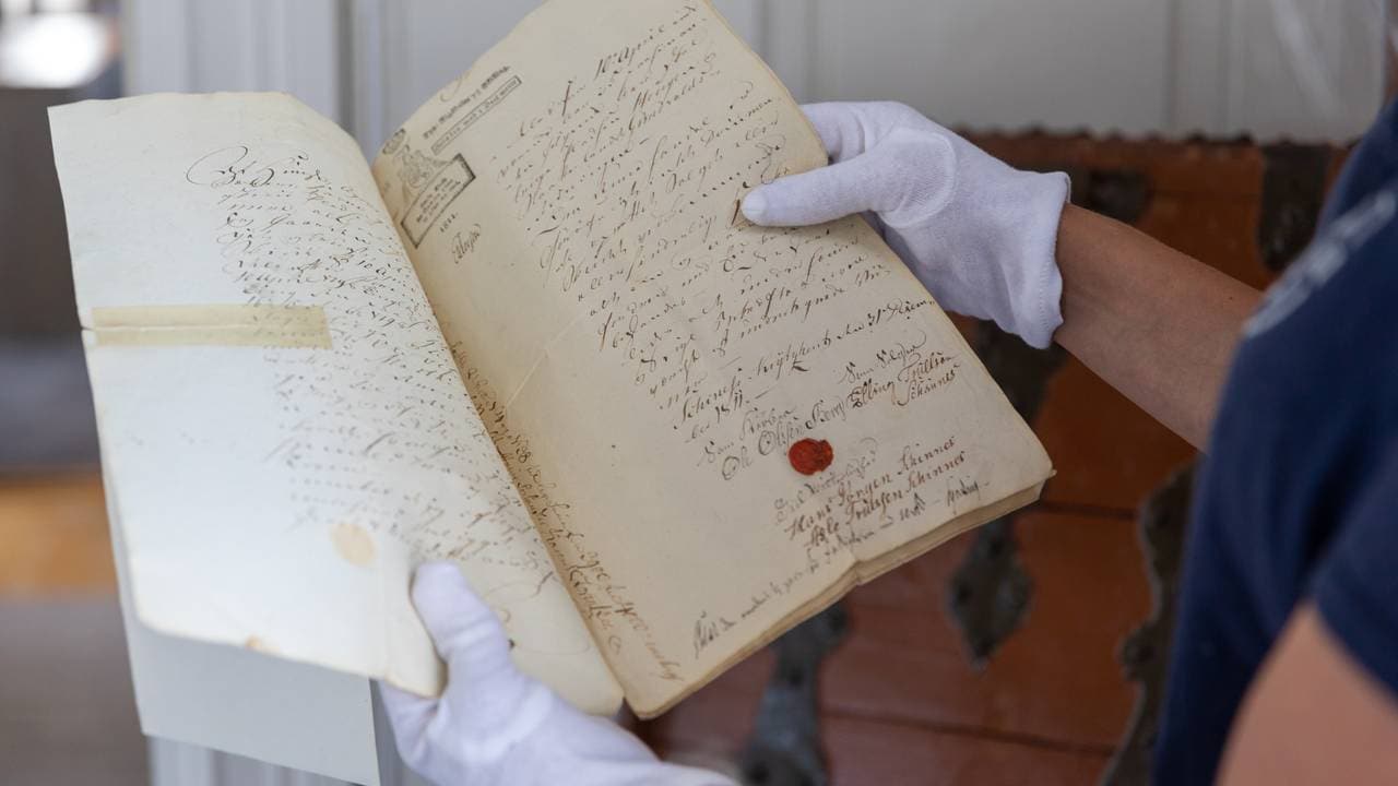 Live Svalastog Skinnes viser frem gamle dokumenter fra Nedre Skinnes Gård