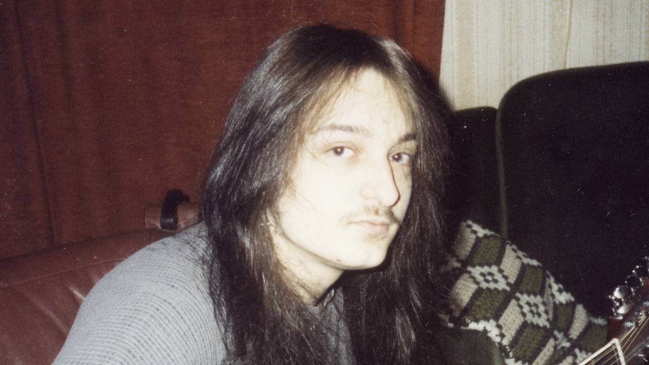 Jørn Stubberud som tenåring, med langt mørkt hår, en liten bart og en kassegitar.
