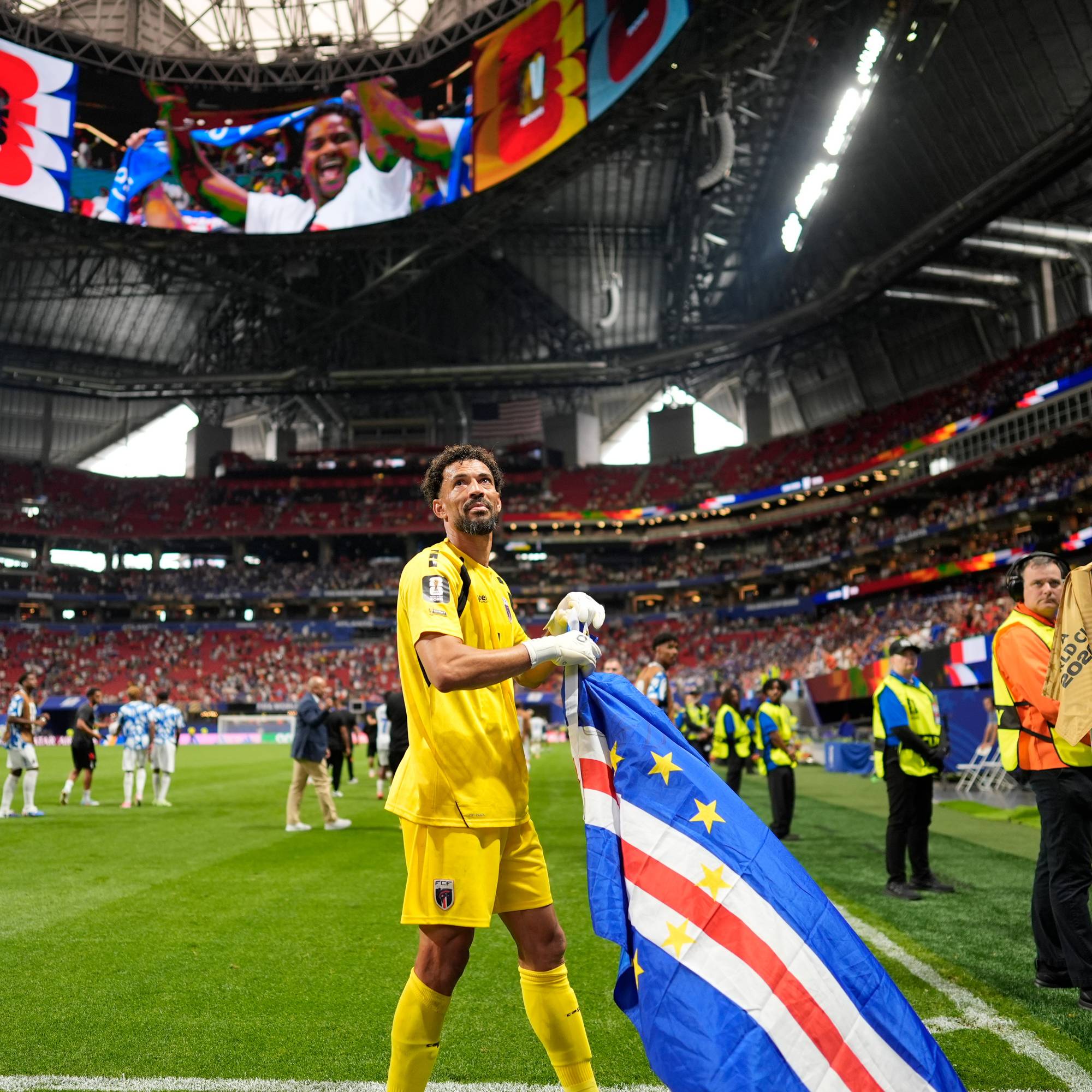 glad mann med flagg på stadion