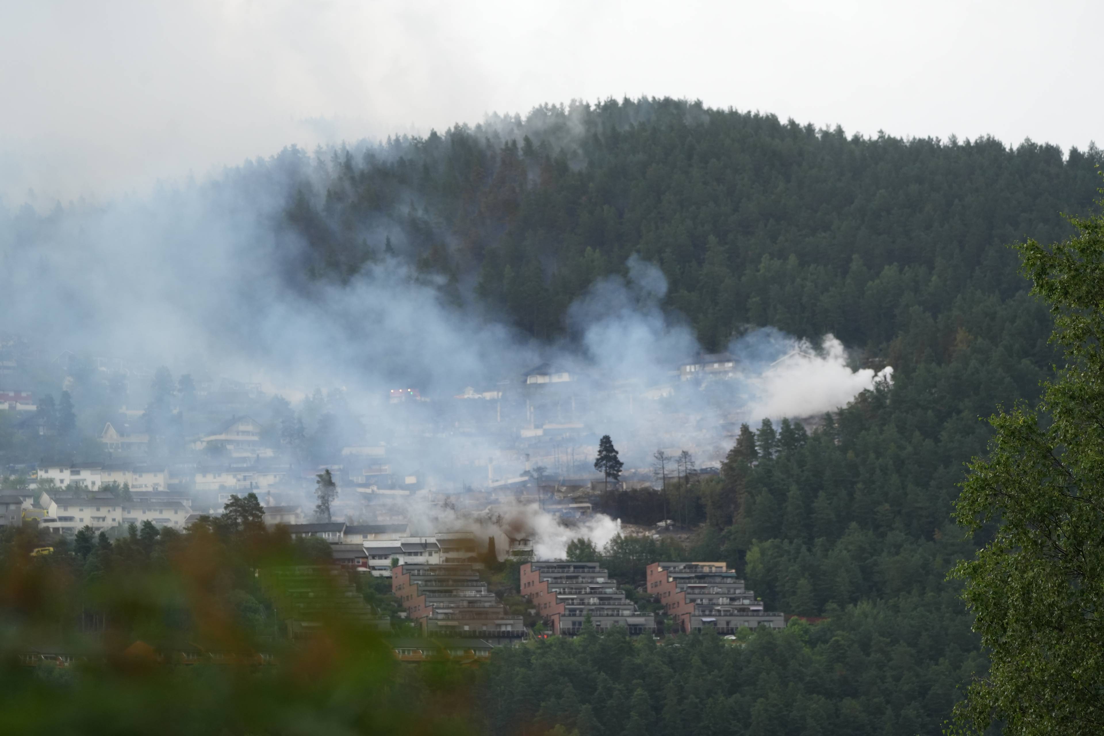 Røyk ulmer i skogen like ved brannområdet.
