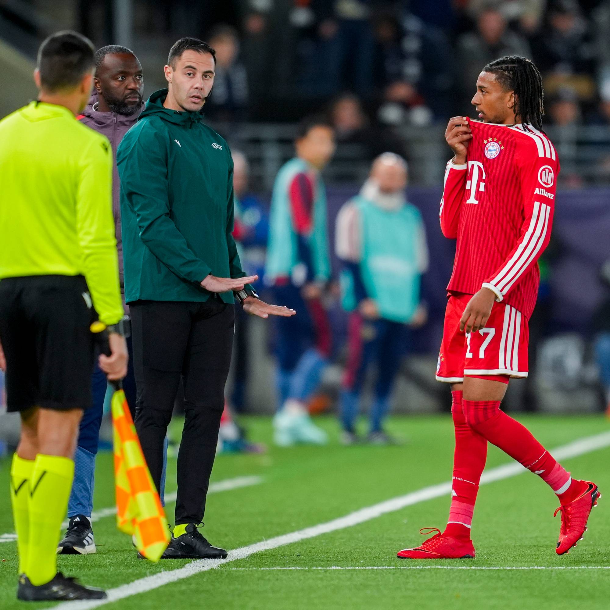 Dommer og Bayern München-spiller snakker sammen på sidelinjen under en fotballkamp. (Bildebeskrivelsen er laget av en KI-tjeneste)