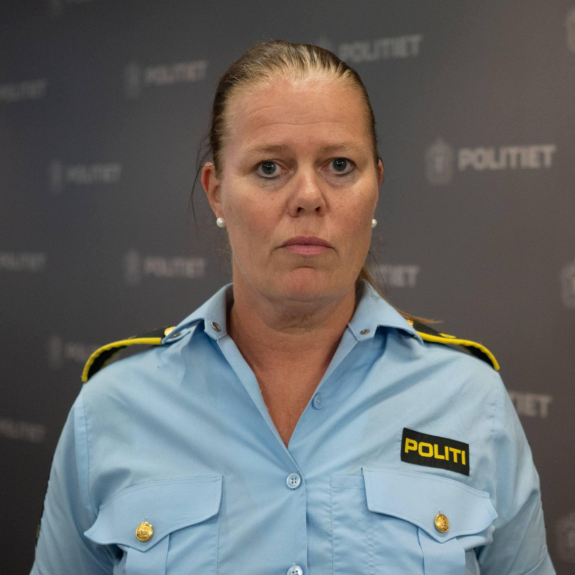 Kvinne i politiuniform ser inn i kamera. Hun har blondt hår samlet i hestehale.