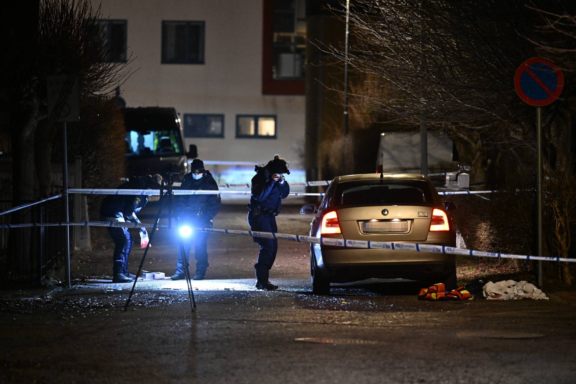 Politi arbeider på et avsperret åsted med en bil om natten. (Bildebeskrivelsen er laget av en KI-tjeneste)