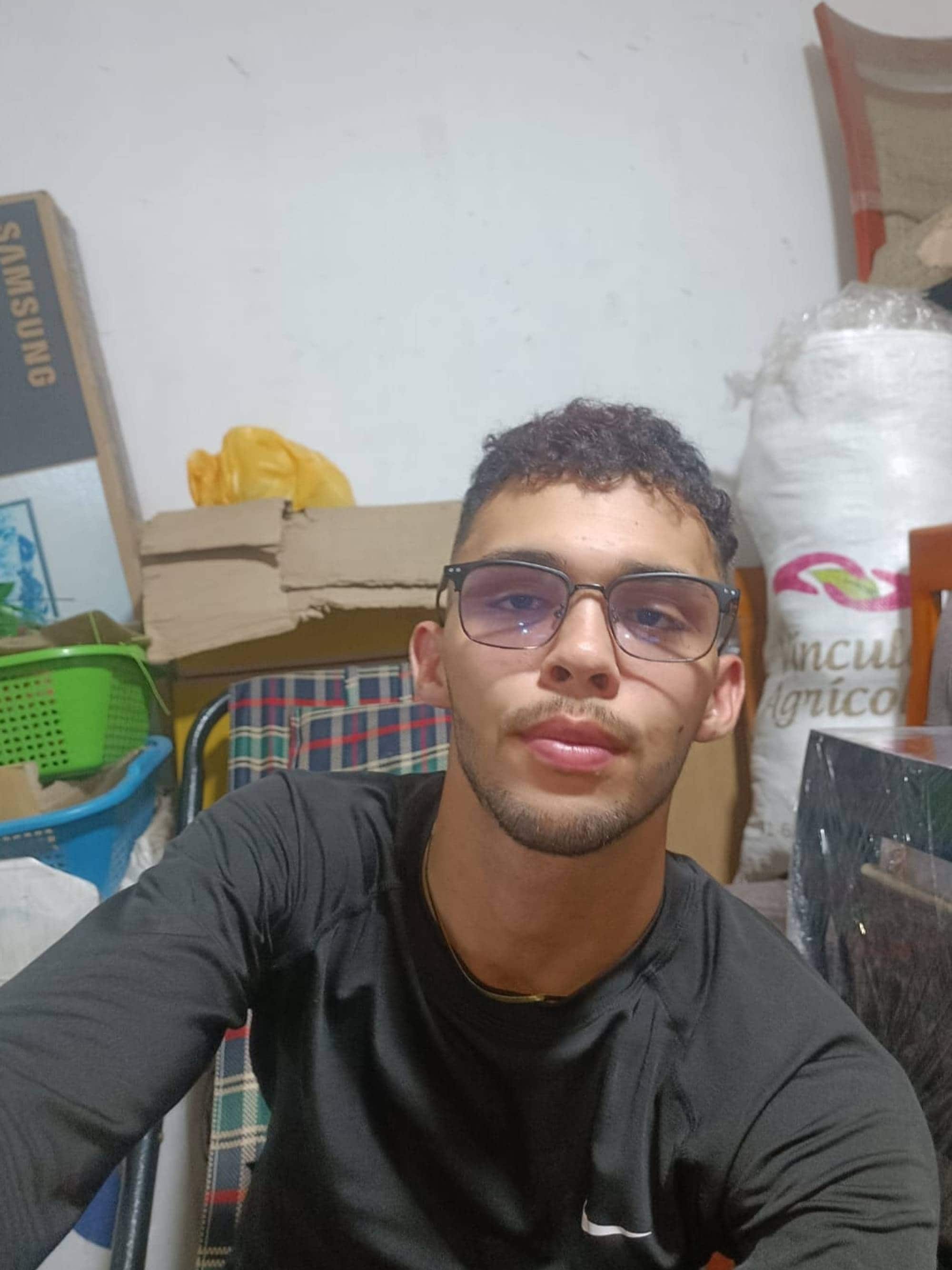 Selfie av Youtuberen Cesar Torrealba. Han sitter foran det som ser ut som et flyttelass, og ser rett inn i kameraet.