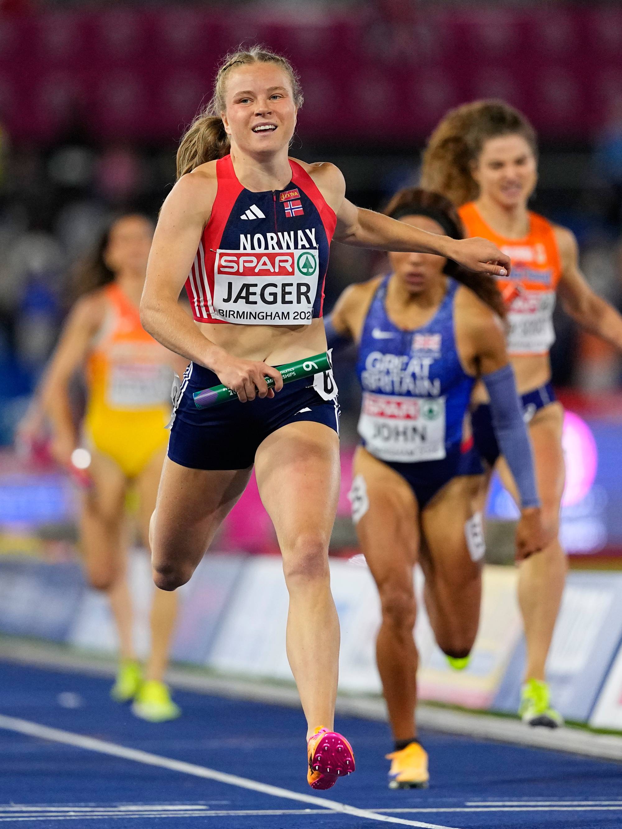 Henriette Jæger løper stafett for Norge på en løpebane med flere konkurrenter bak seg. (Bildebeskrivelsen er laget av en KI-tjeneste)