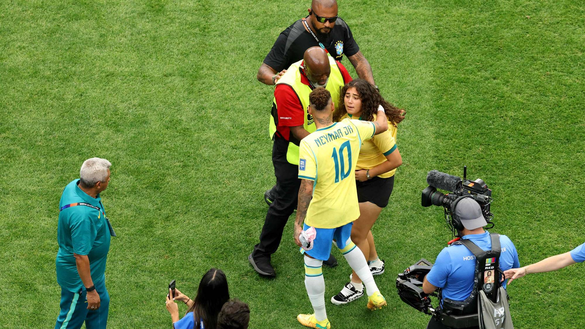 Neymar klemmer en supporter på banen etter en fotballkamp, omgitt av vakter og presse. (Bildebeskrivelsen er laget av en KI-tjeneste)