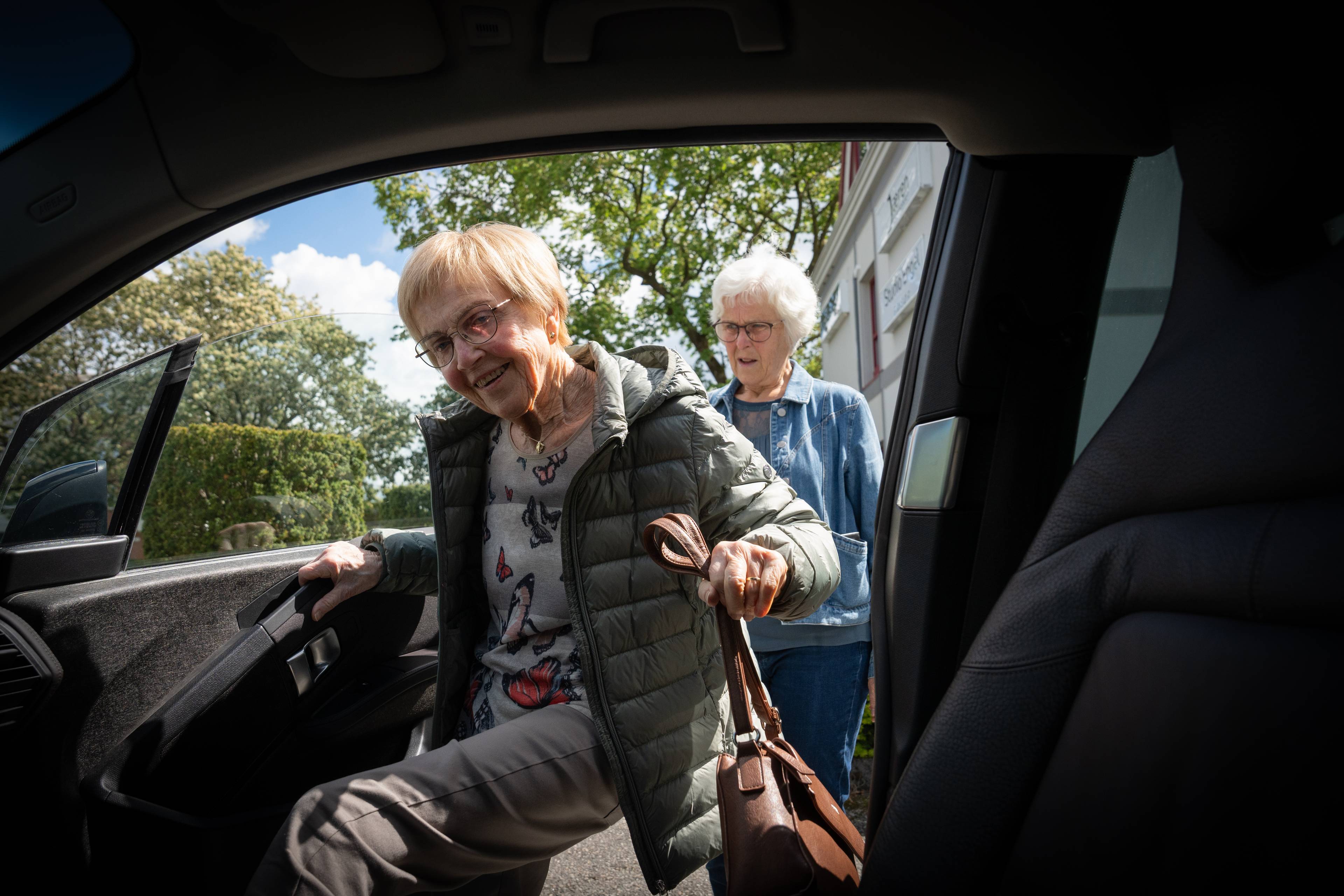 Synnøve Salte hjelper moren sin inn i bilen
