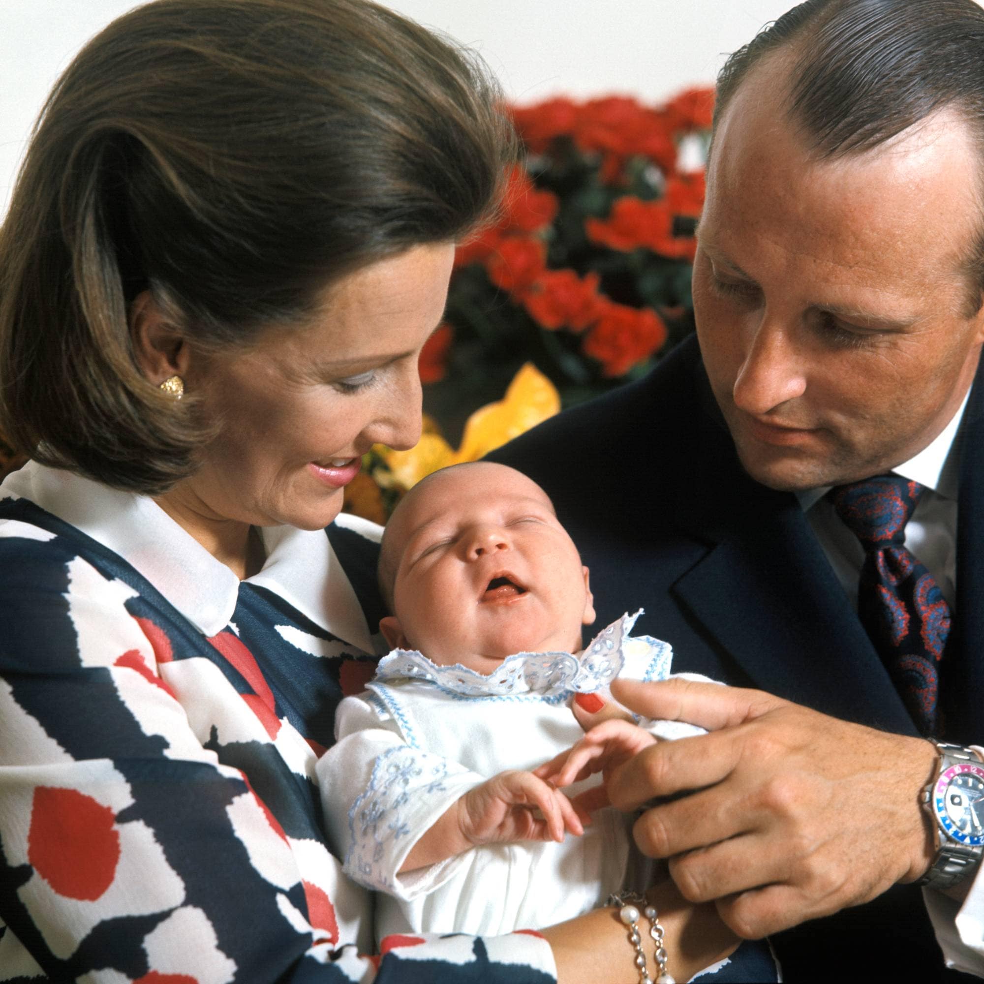 Kronprinsesse Sonja holder den nyfødte prins Haakon Magnus i armene, mens kronprins Harald holder den lille gutten i hånden. De er fotografert på Rikshospitalet i Oslo få dager etter fødselen.