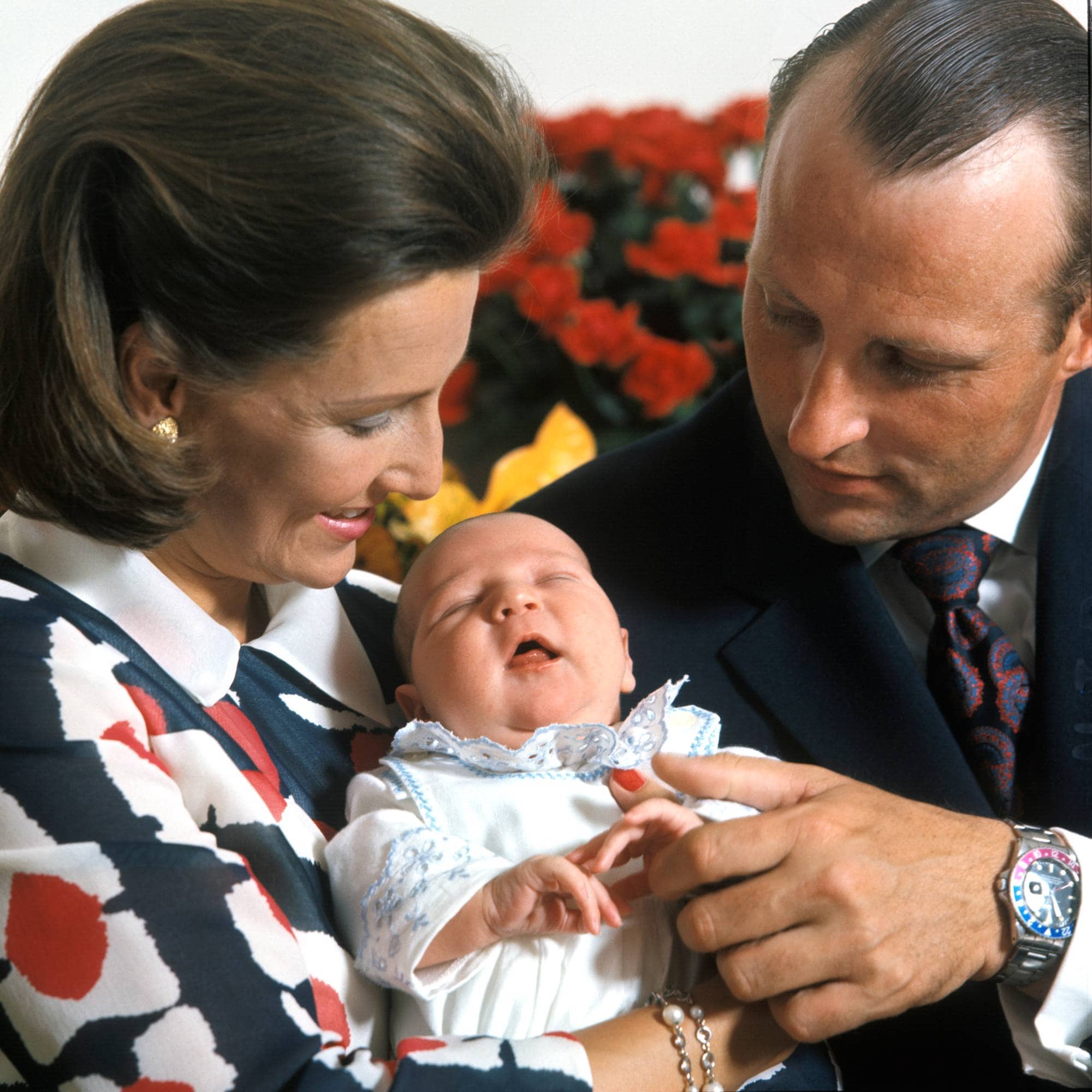Kronprinsesse Sonja holder den nyfødte prins Haakon Magnus i armene, mens kronprins Harald holder den lille gutten i hånden. De er fotografert på Rikshospitalet i Oslo få dager etter fødselen.