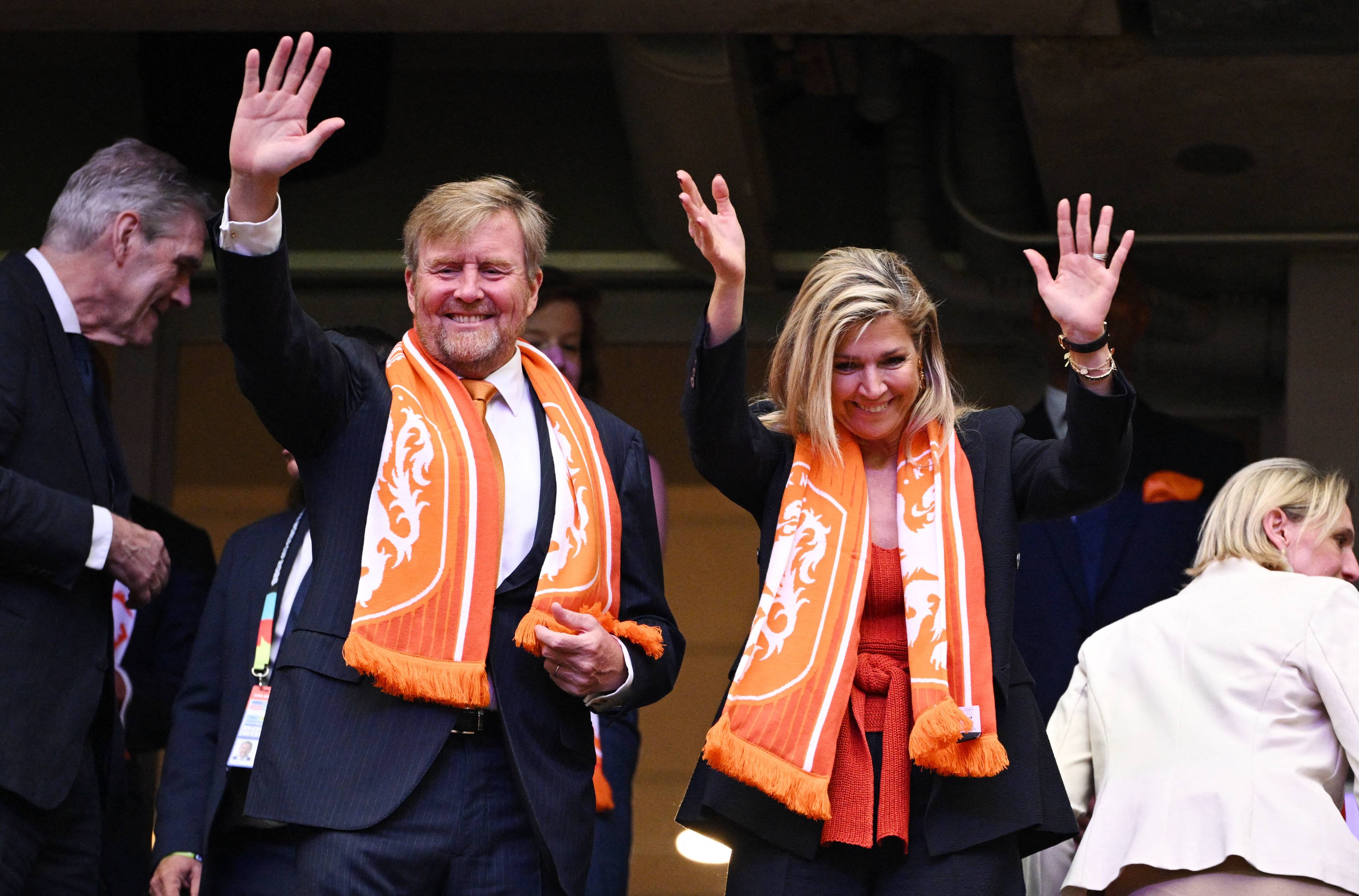 Kong Willem-Alexander og dronning Mxima vinker fra tribunen