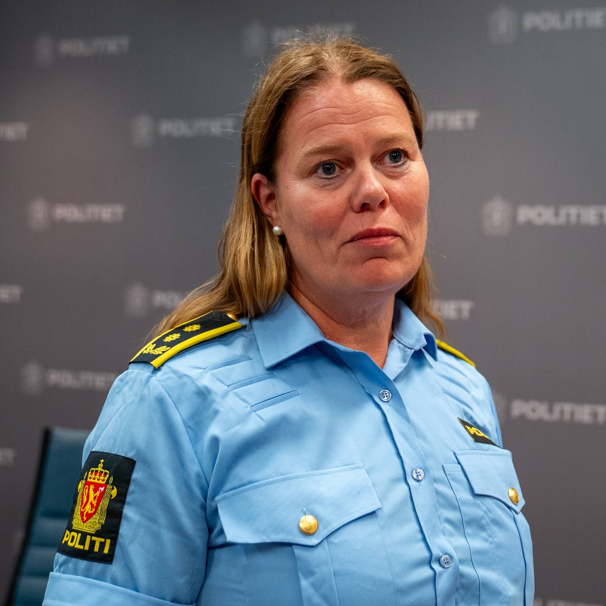En kvinnelig politileder i uniform foran en vegg med Politiet-logoer. (Bildebeskrivelsen er laget av en KI-tjeneste)