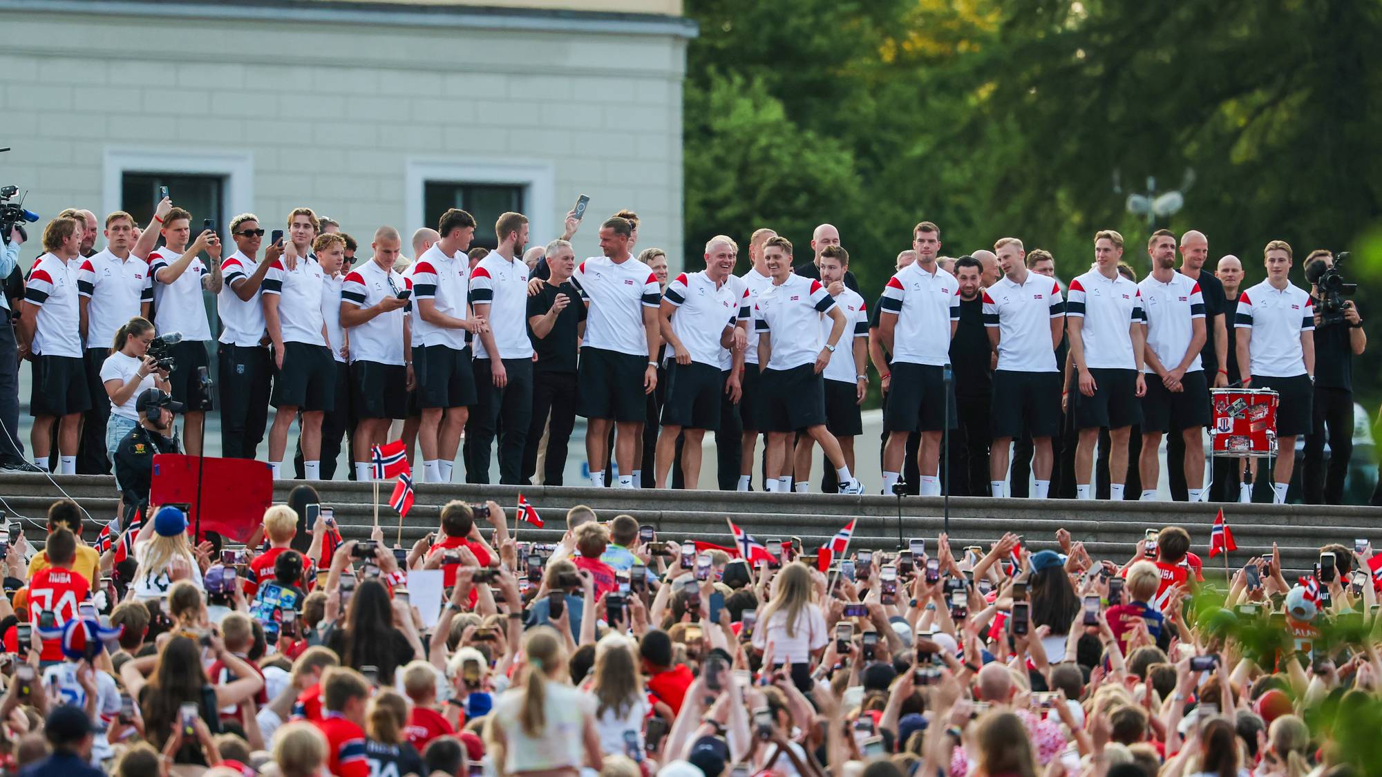 Det norske herrelandslaget i fotball hilser en folkemengde fra Slottsbalkongen. (Bildebeskrivelsen er laget av en KI-tjeneste)