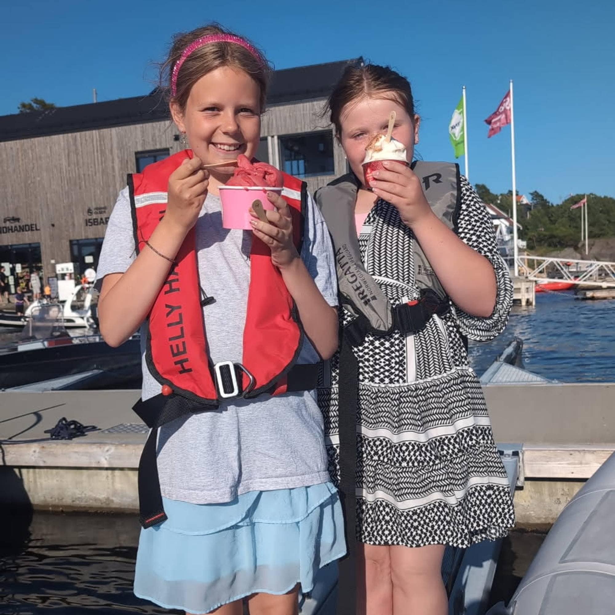 To jenter spiser is på ei brygge.