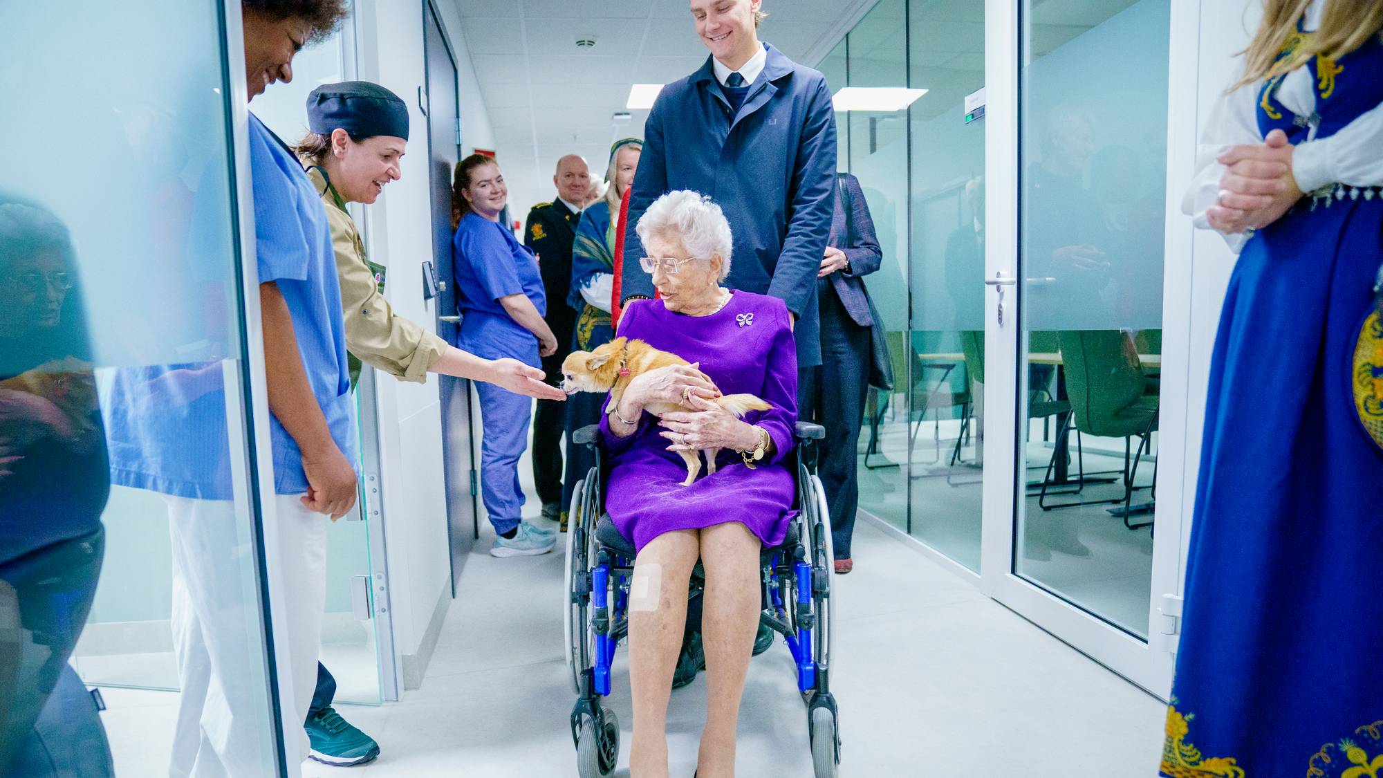 Ansatte smiler og klapper hunden Wilma, som sitter på fanget til prinsesse Astrid under åpningen av nytt helsehus i Lørenskog i 2023.