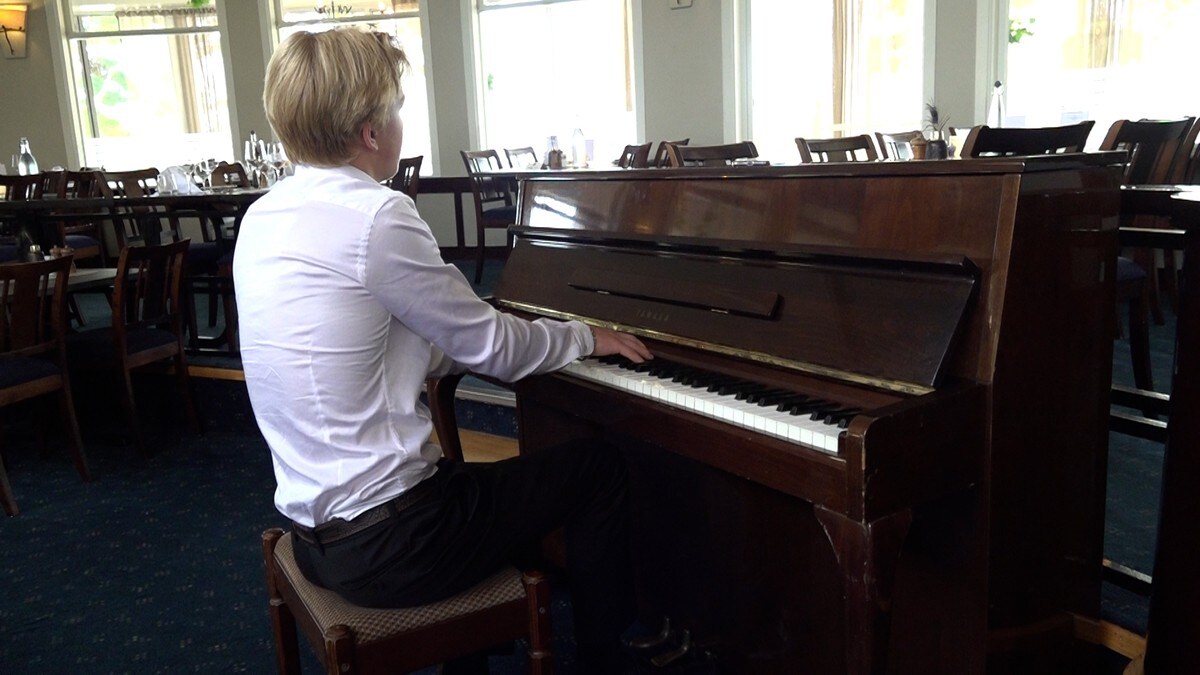 Håkon (14 år) spiller taffelmusikk på Strand Hotel Fevik i sommer