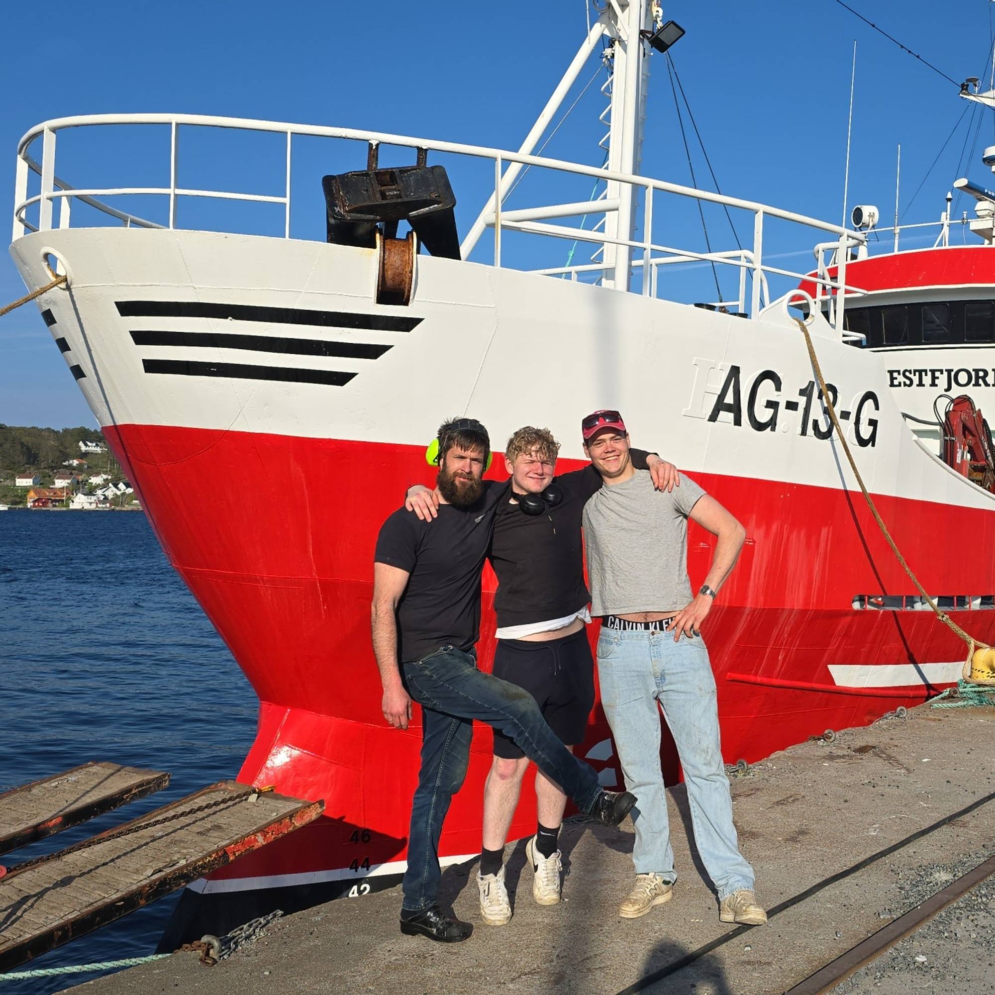 Fiskebåten Vestfjord med mannskap, Grimstad. Rød tråler til kai. Mannskap foran på kai.