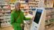 Foto: Dina Nybø Olavsen / NRK Eva Kristine Kirkevik står foran kølapp-automaten på Apotek 1. Hun holder hånden på automaten, som ikke et tilrettelagt for blinde og svaksynte, da touchskjerm gjør det vanskelig å finne hvor man skal trykke.