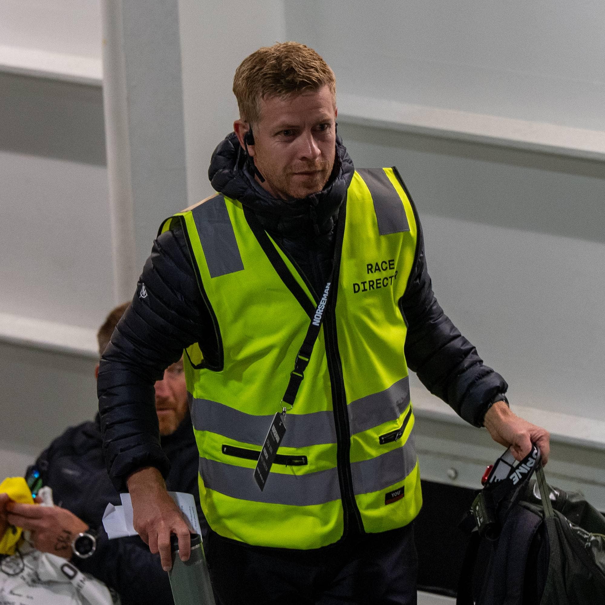 En mann med gul refleksvest merket Race Director. (Bildebeskrivelsen er laget av en KI-tjeneste)