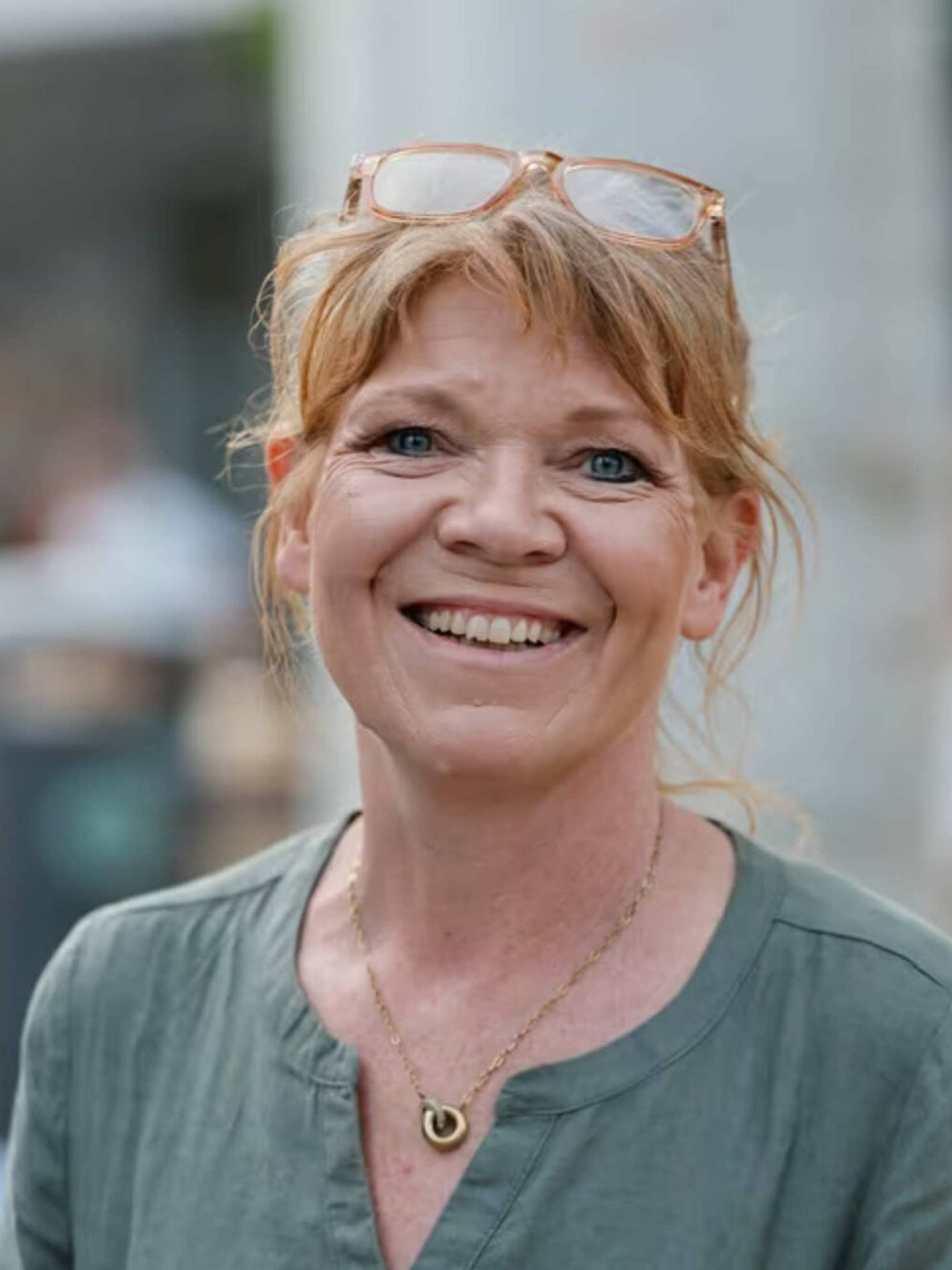 Kvinne som smiler inn i kamera