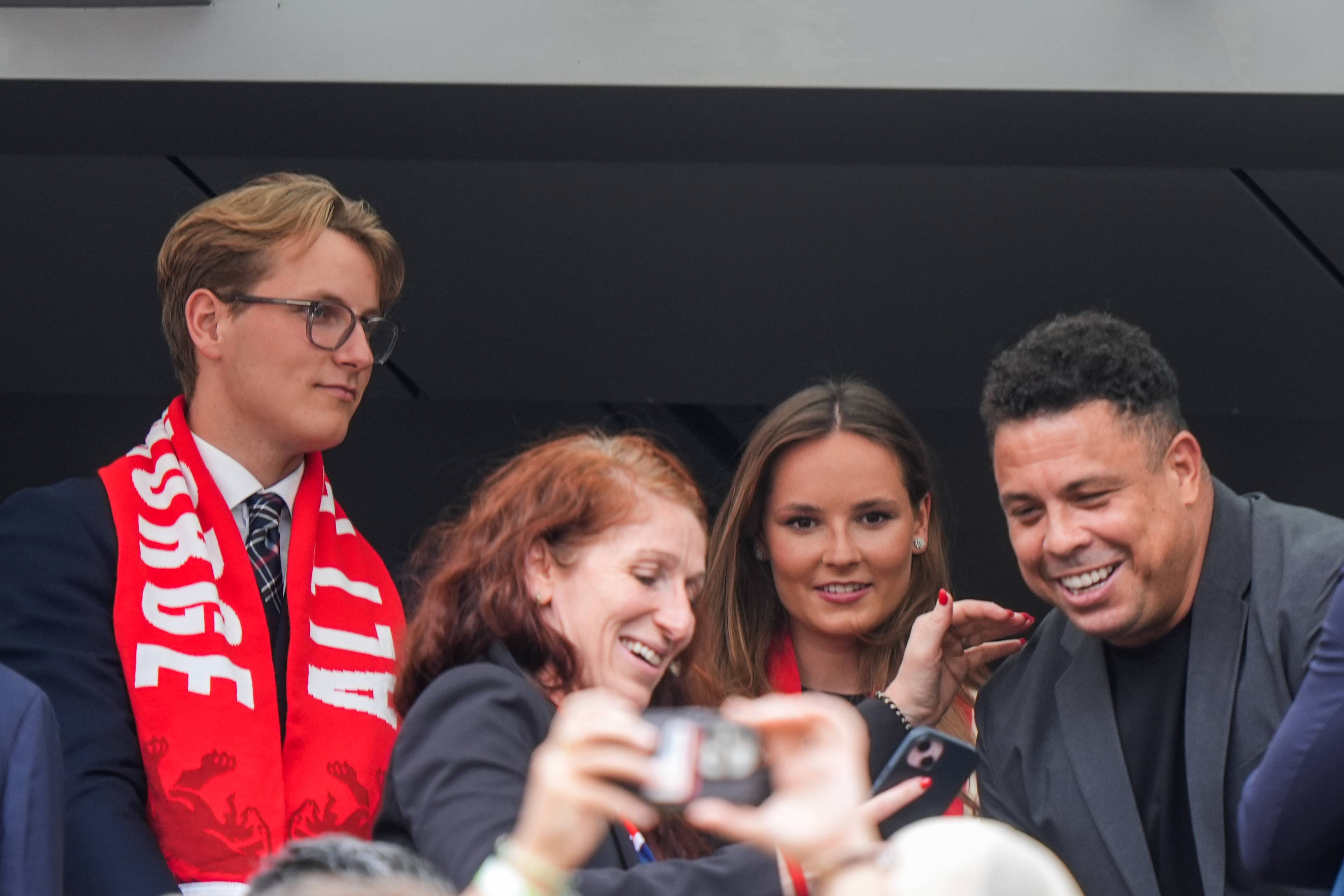 Prins Sverre Magnus og Ronaldo Nazário sammen med andre på en tribune under en fotballkamp. (Bildebeskrivelsen er laget av en KI-tjeneste)