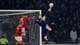 Russell Cheyne / REUTERS,NTB En fotballspiller i blå drakt sparker ballen baklengs i luften. To spillere i rød drakt er ved siden av ham ved et fotballmål. (Bildebeskrivelsen er laget av en KI-tjeneste)