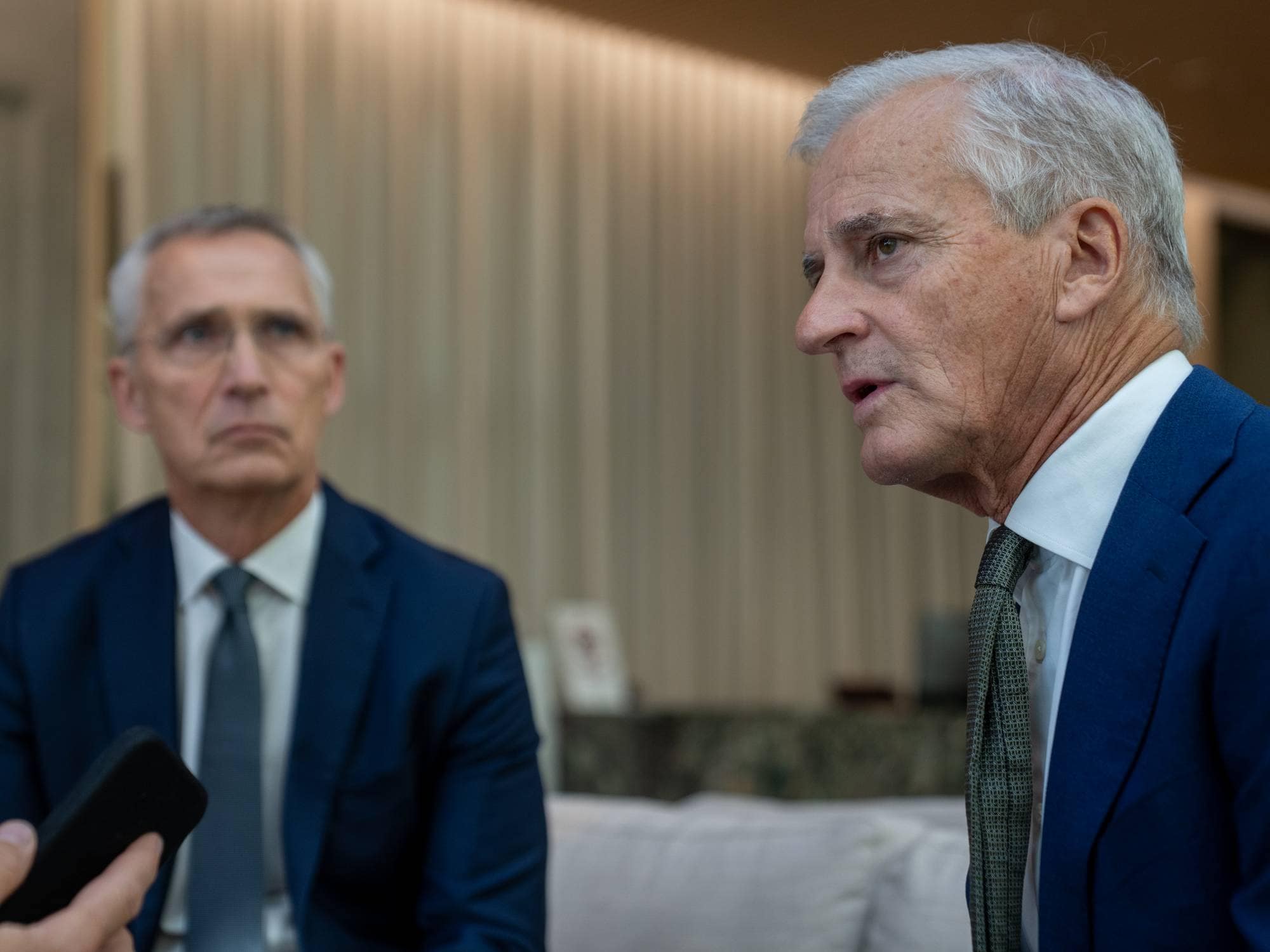 Finansminister Jens Stoltenberg og statsminister Jonas Gahr Støre intervjues før årets siste budsjettkonferanse på Statministerens kontor. Stills er tatt på forværelset til Statministerens nye kontor i D-blokka i det nye Regjeringskvartalet. Ellers er Stoltenberg og Støre på balkongen utenfor SMK. Stoltenberg viser Støre Arbeiderpartiets hovedkontor i Folketeaterbygningen på Youngstorvet, som skimtes i bakgrunnen.
