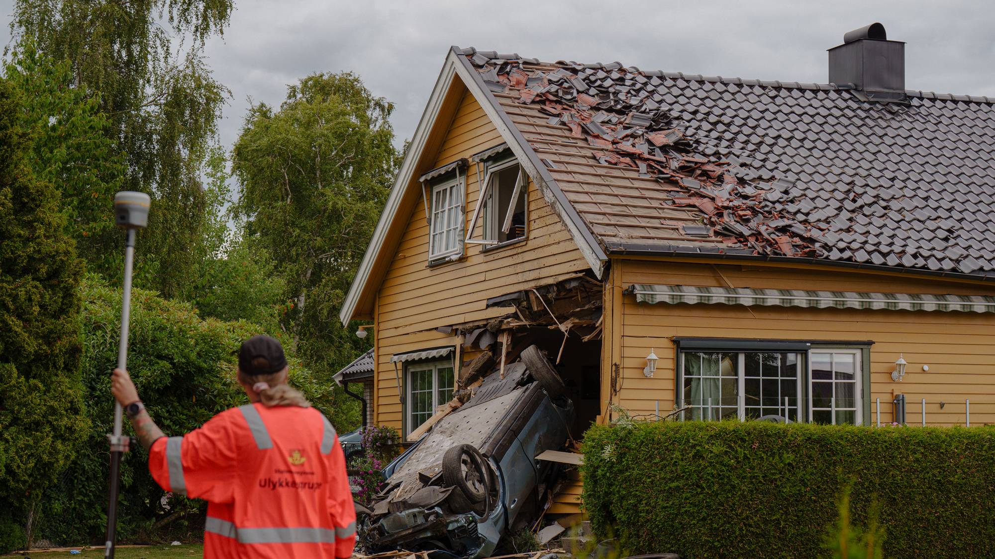 En bil har krasjet inn i en enebolig og forårsaket store skader. Ulykkesgruppe undersøker stedet. (Bildebeskrivelsen er laget av en KI-tjeneste)