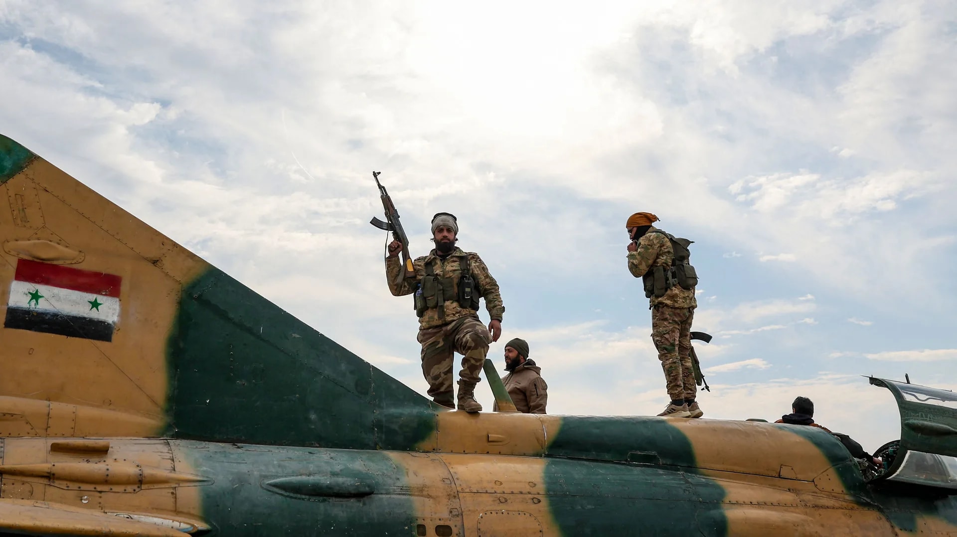 Rebel soldiers stand on top of a Syrian military plane after they captured a military airbase near the city of Hama, December 6, 2024.