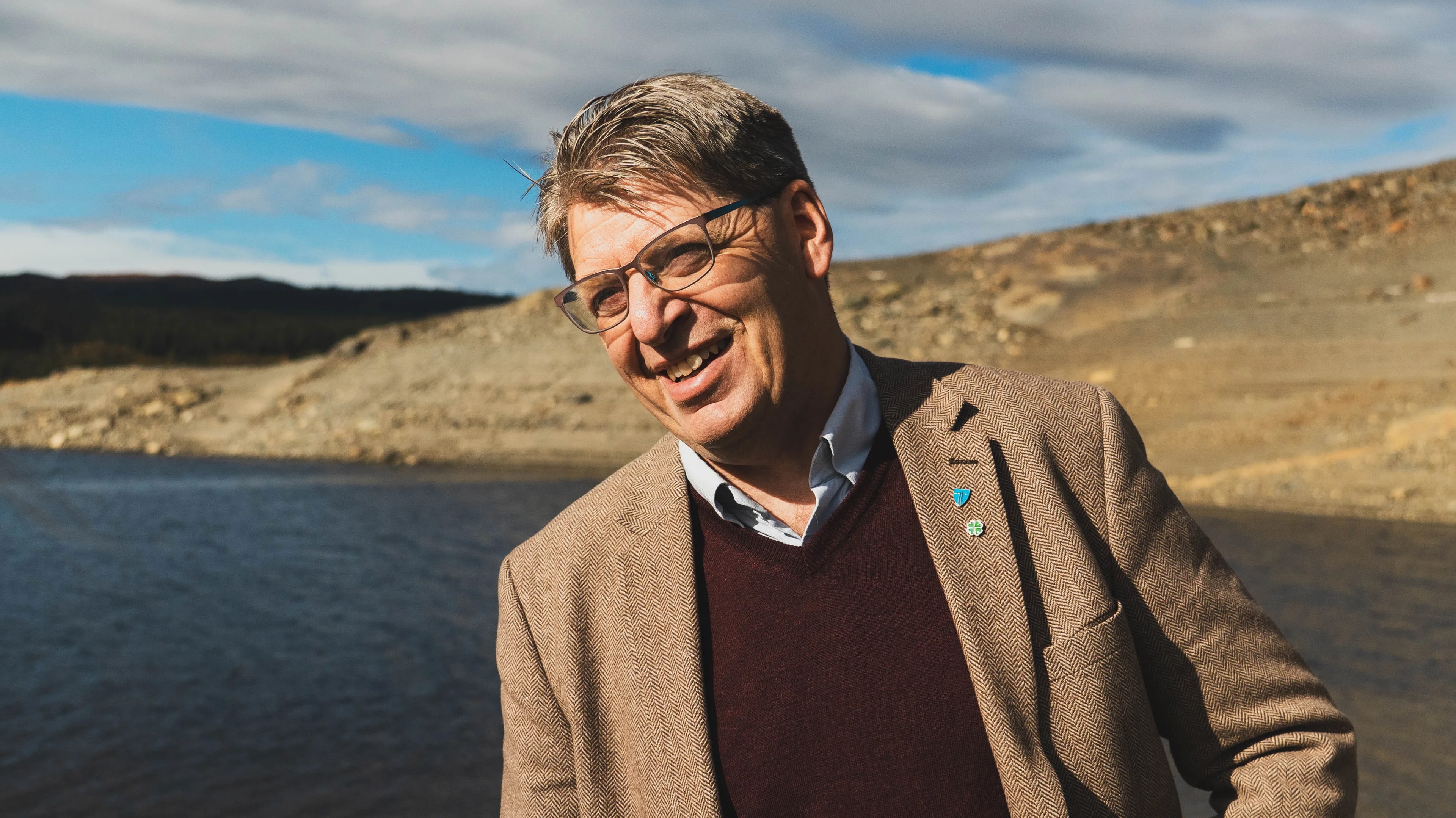 En mann med grått hår og blazer