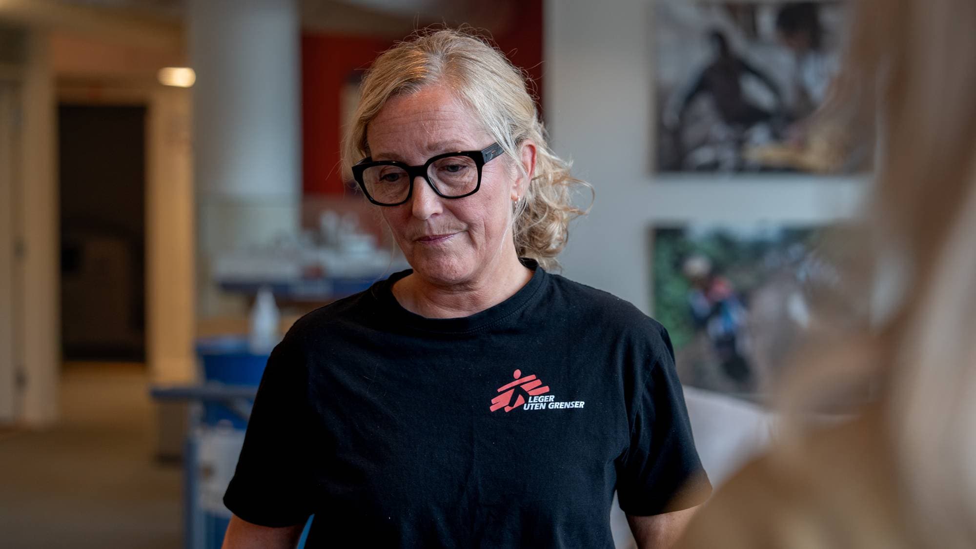Lyshåret kvinne ser ned i gulvet