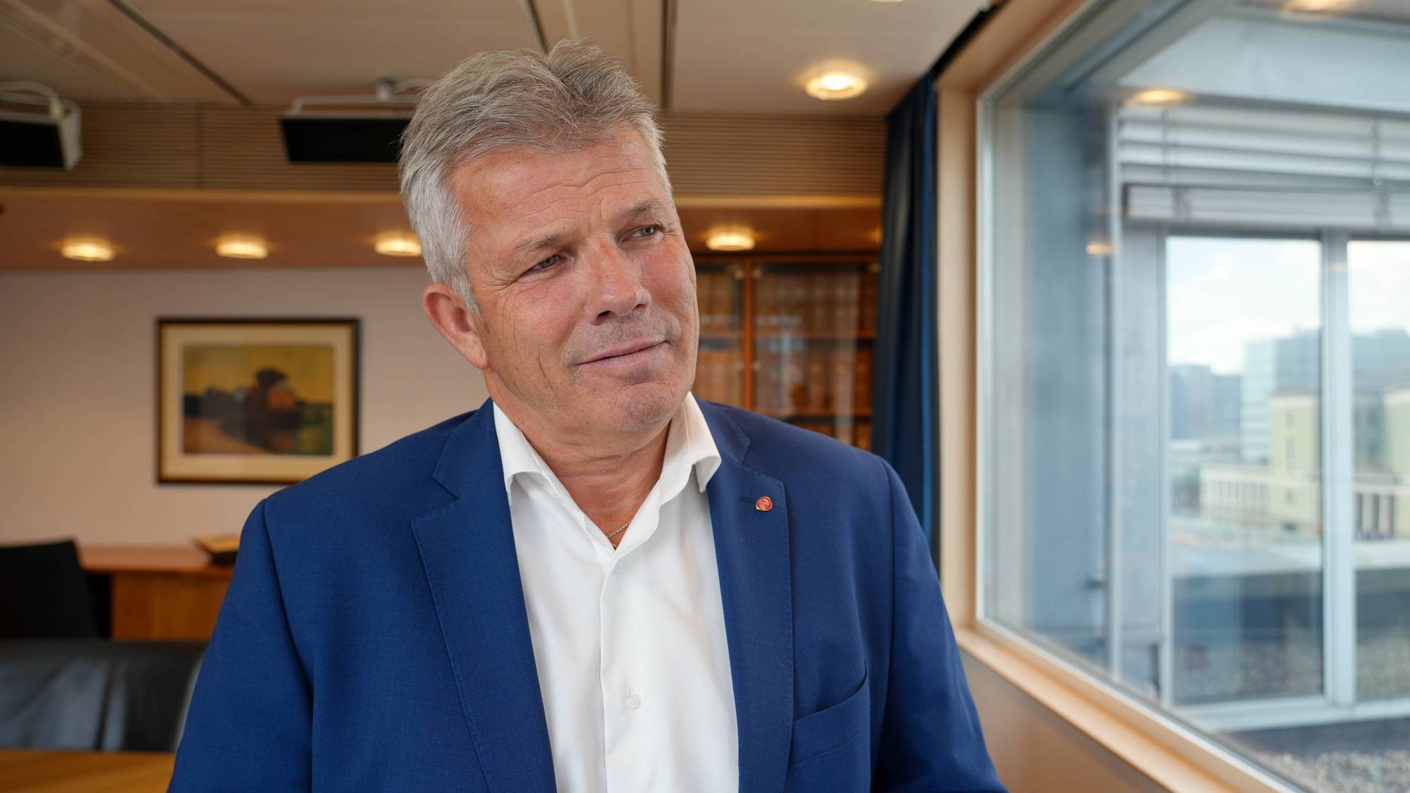 en mann i blå dress (Bildebeskrivelsen er laget av en KI-tjeneste)