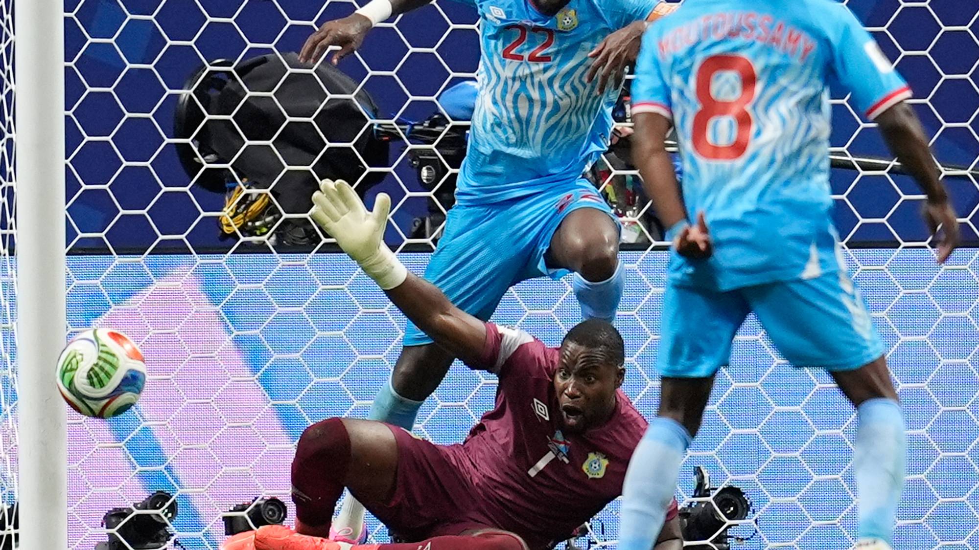 Fotballkeeper kaster seg for å redde ballen foran mål med med- og motspillere. (Bildebeskrivelsen er laget av en KI-tjeneste)