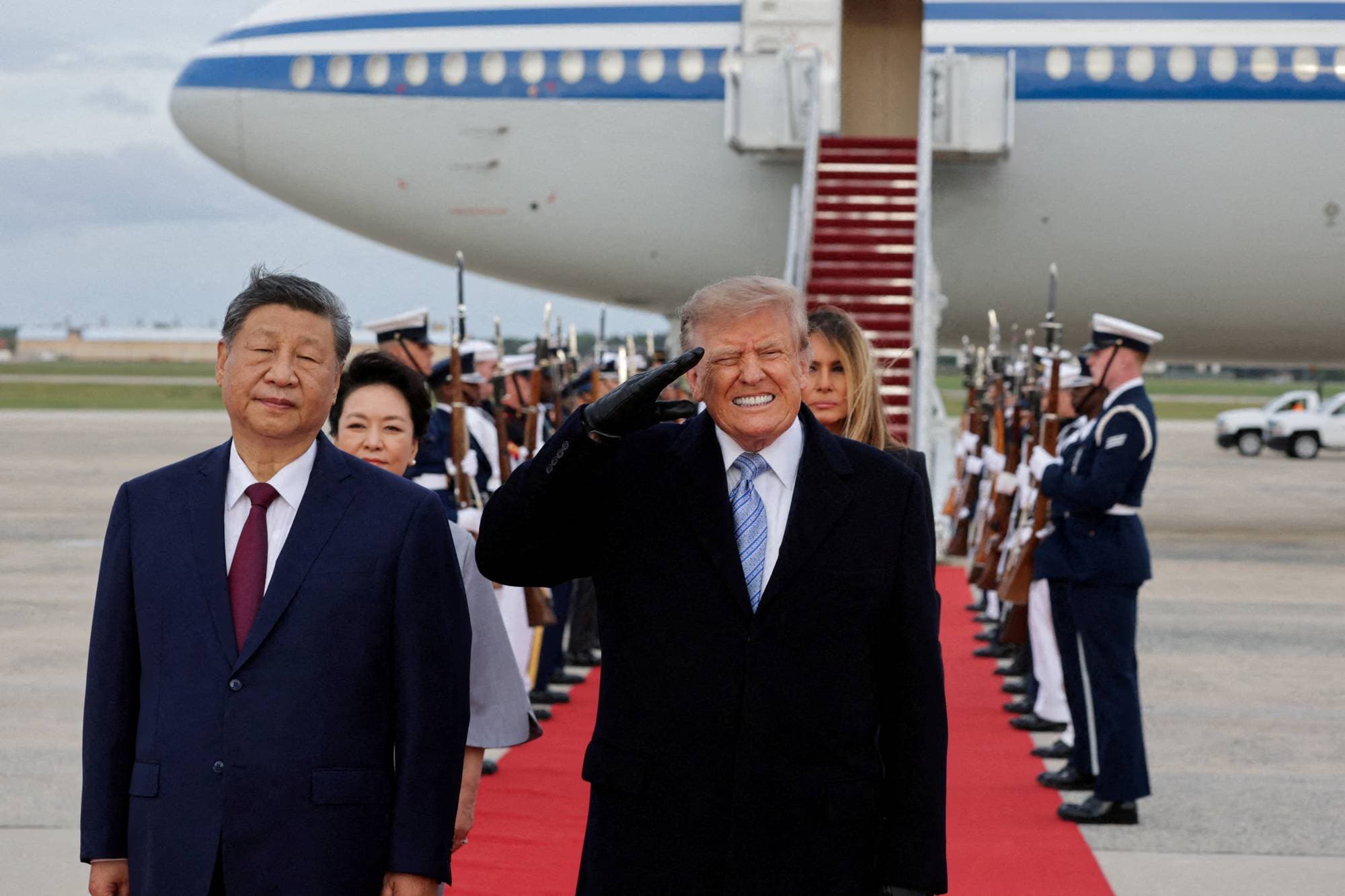 Donald Trump og Xi Jinping foran fly på rullebane, flankert av æresvakter. Illustrasjon. (Bildebeskrivelsen er laget av en KI-tjeneste)