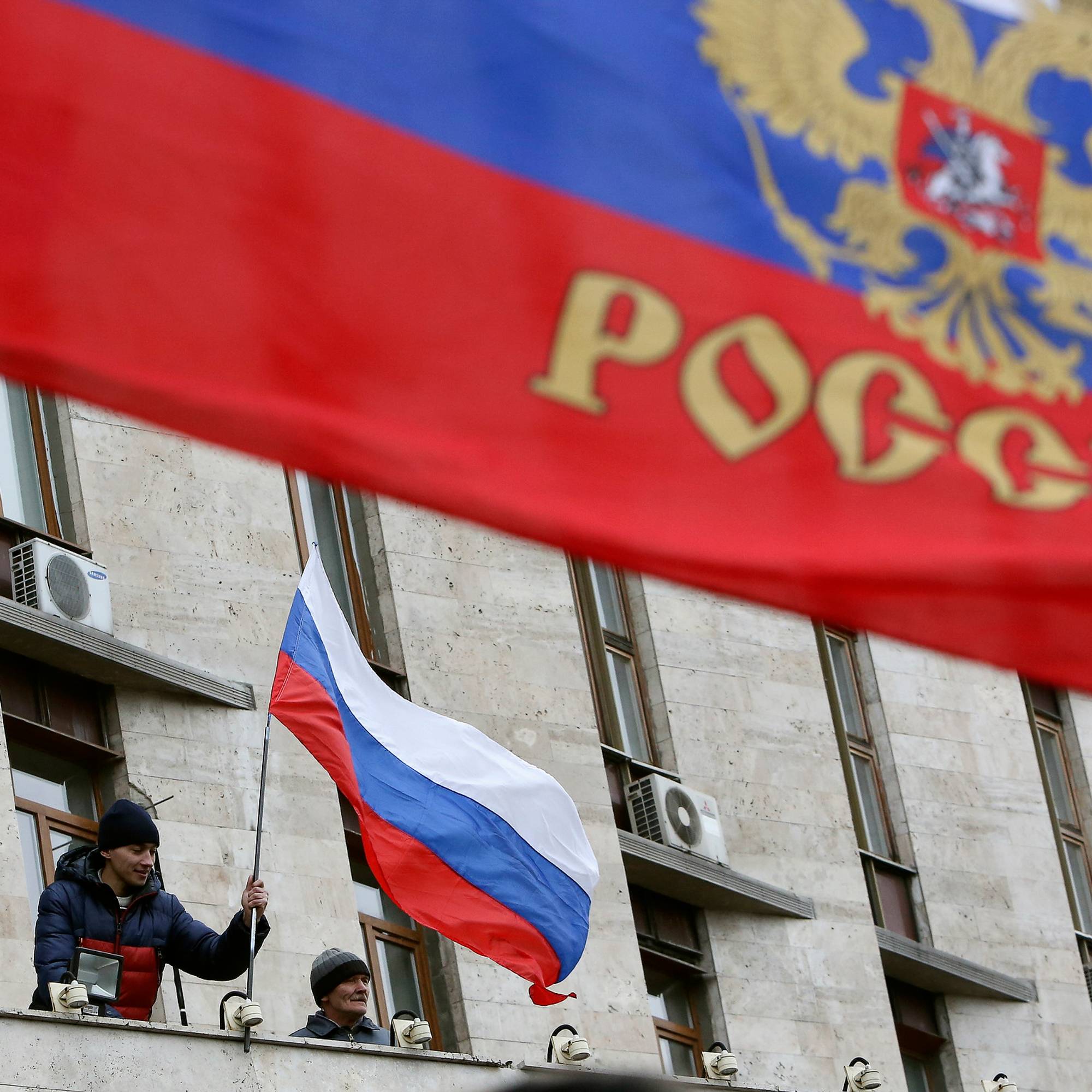 russisk flagg blir heist på offentlig bygning i donetsk