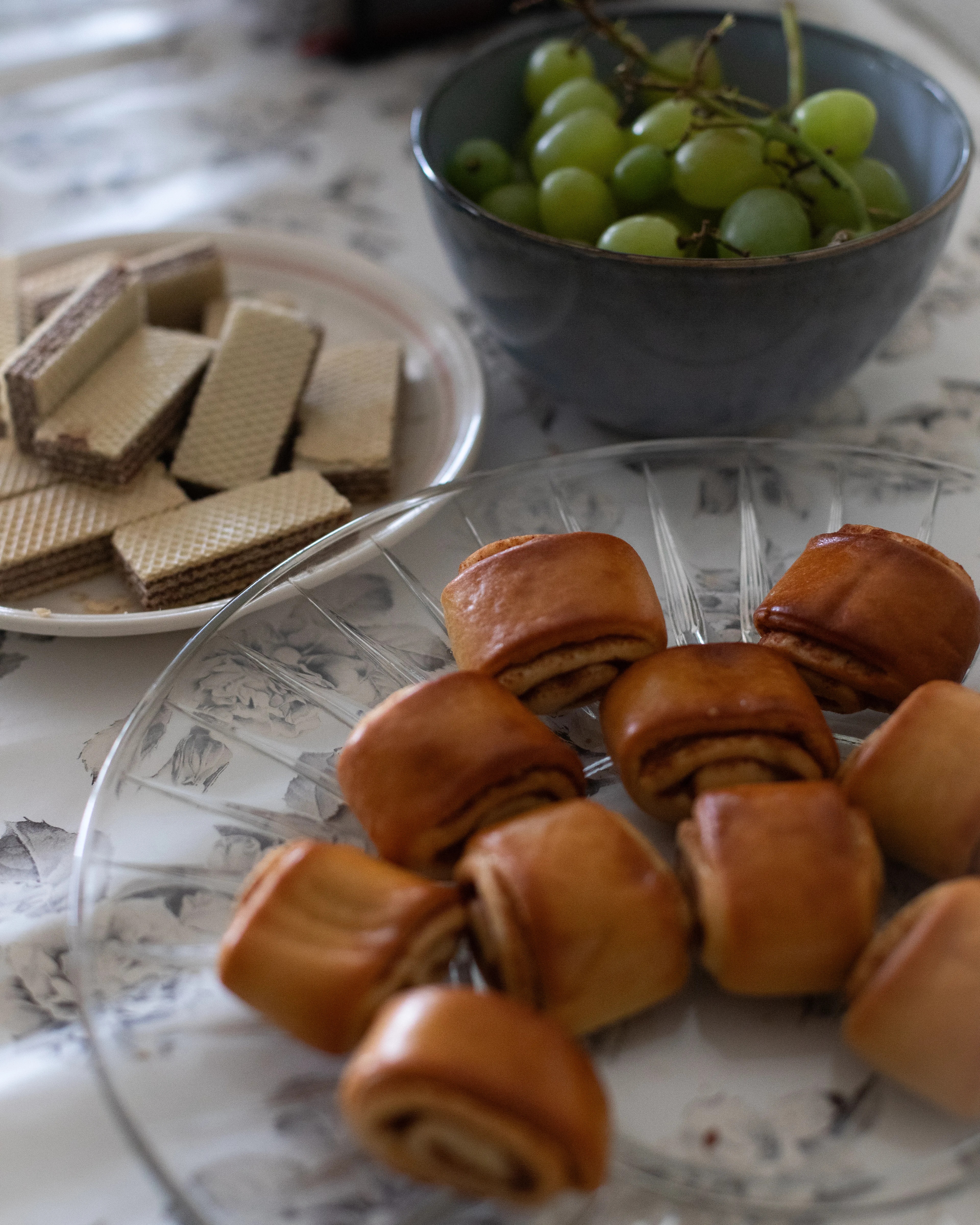 kanelboller, kjeks og frukt på fat