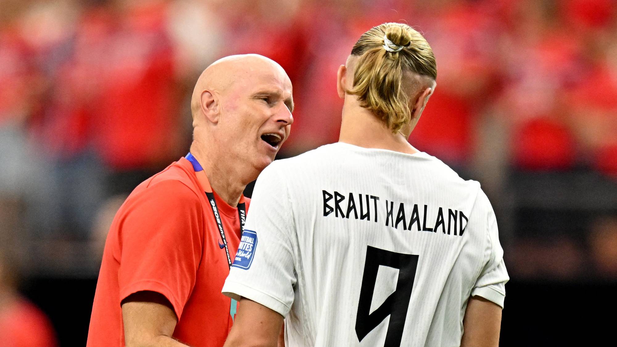 Landslagstrener Ståle Solbakken snakker med Erling Braut Haaland på en fotballbane. (Bildebeskrivelsen er laget av en KI-tjeneste)