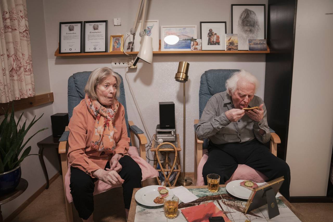 Ekteparet sitter i hver sin blå lenestol, på hver sin rosa pute. De spiser pannekaker til kveldsmat, hvor Birger kun slikker av syltetøyet på pannekaken sin.